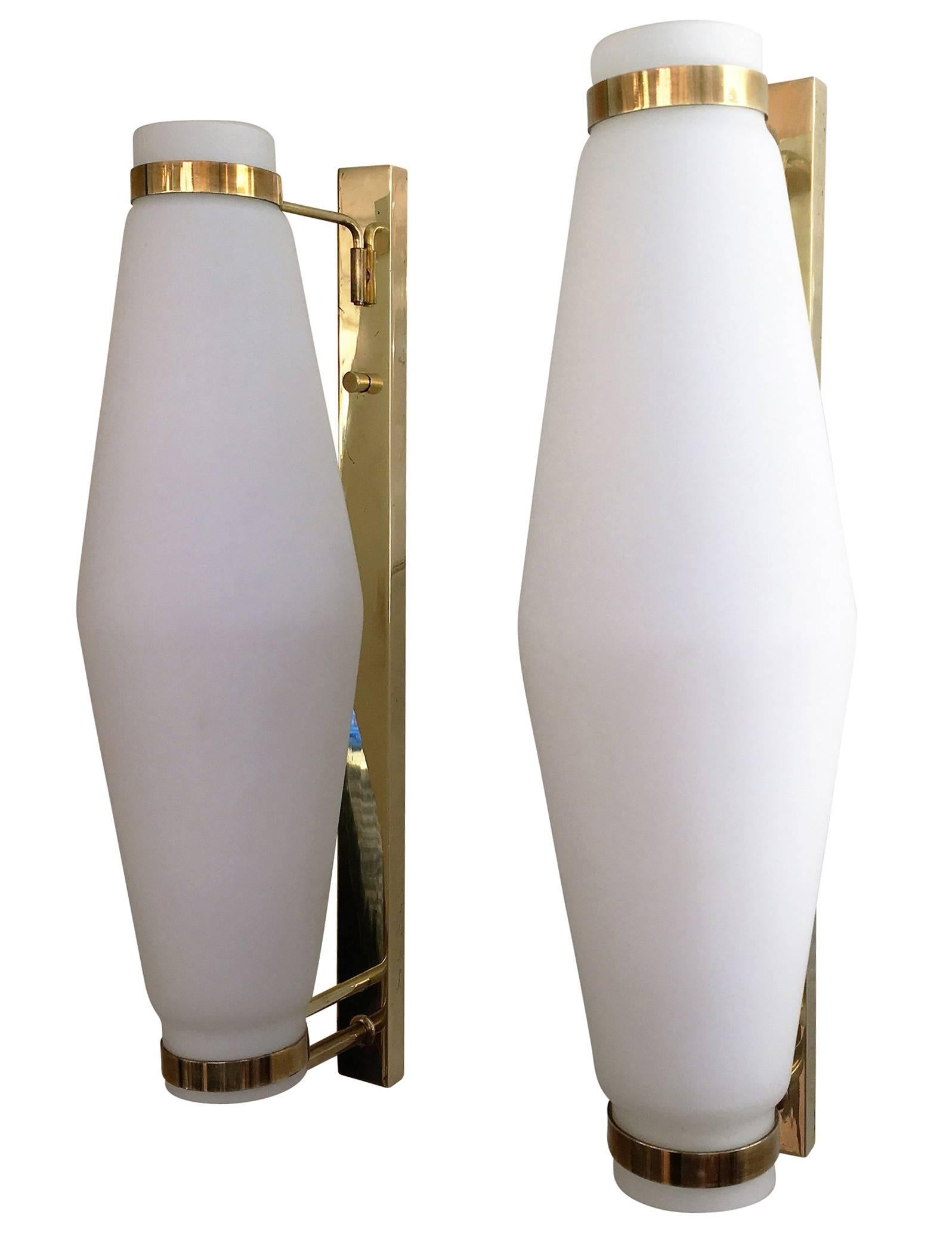 Elegant pair of elongated sconces possibly manufactured by Stilnovo or Arredoluce in the 1960s. They feature a frosted glass shade which is tapered at the ends. The hardware is brass and each holds one candelabra socket.
