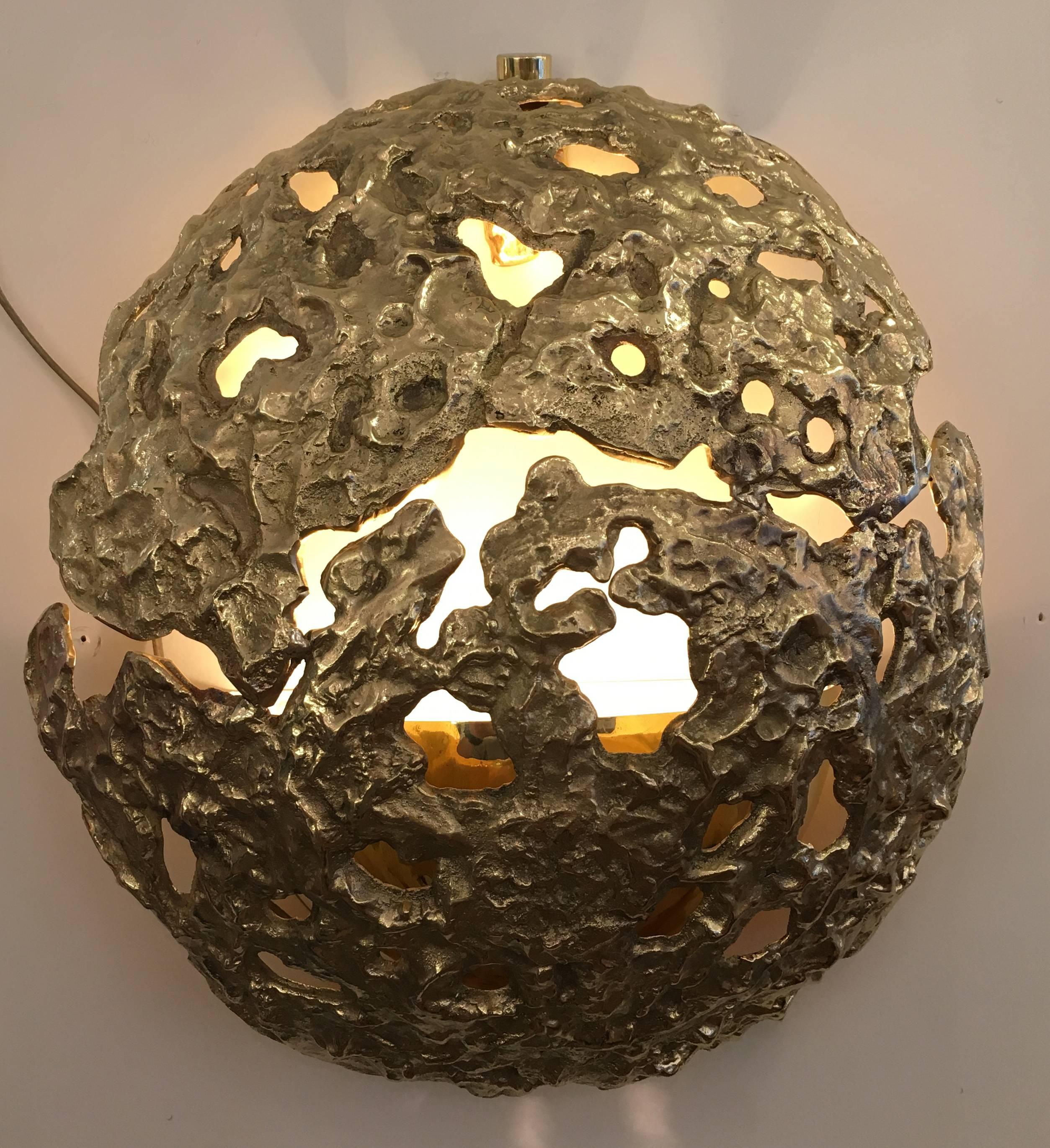 Sculptural cast bronze wall light designed by Angelo Brotto for Italian lighting company Esperia. The perforations throughout the fixtures create an enchanting light effect. Exclusively available at Gaspare Asaro-Italian Modern. Smaller version
