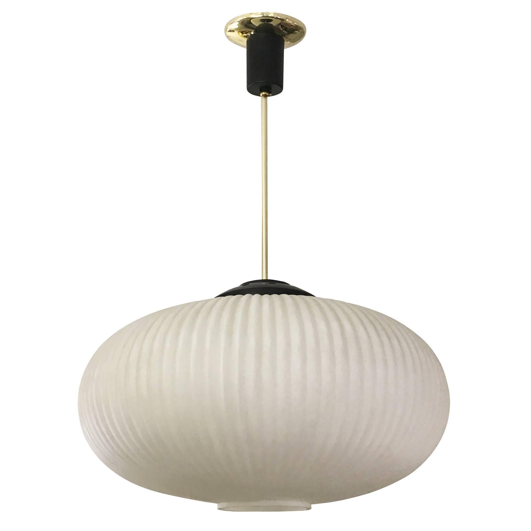 Elegant Mid-Century pendant in the manner of Stilnovo with a large ribbed frosted glass shade. The hardware and stem are lacquered black and brass. Holds one regular socket.