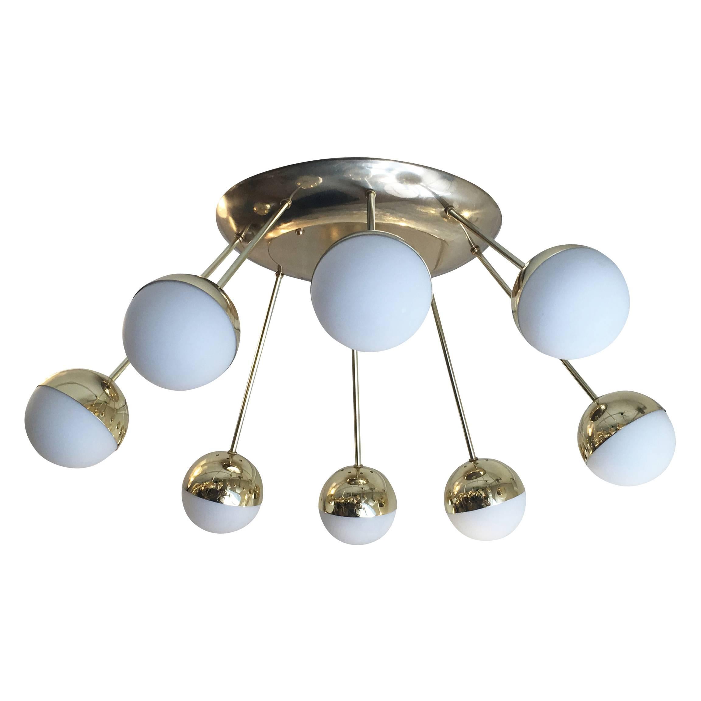 Flush mount fixture composed of eight frosted glass globes departing from a large oval canopy. The globe holders are brass while the canopy is brass plated cast aluminium. Custom produced in late, 1990s for a villa in Italy. Two available.
