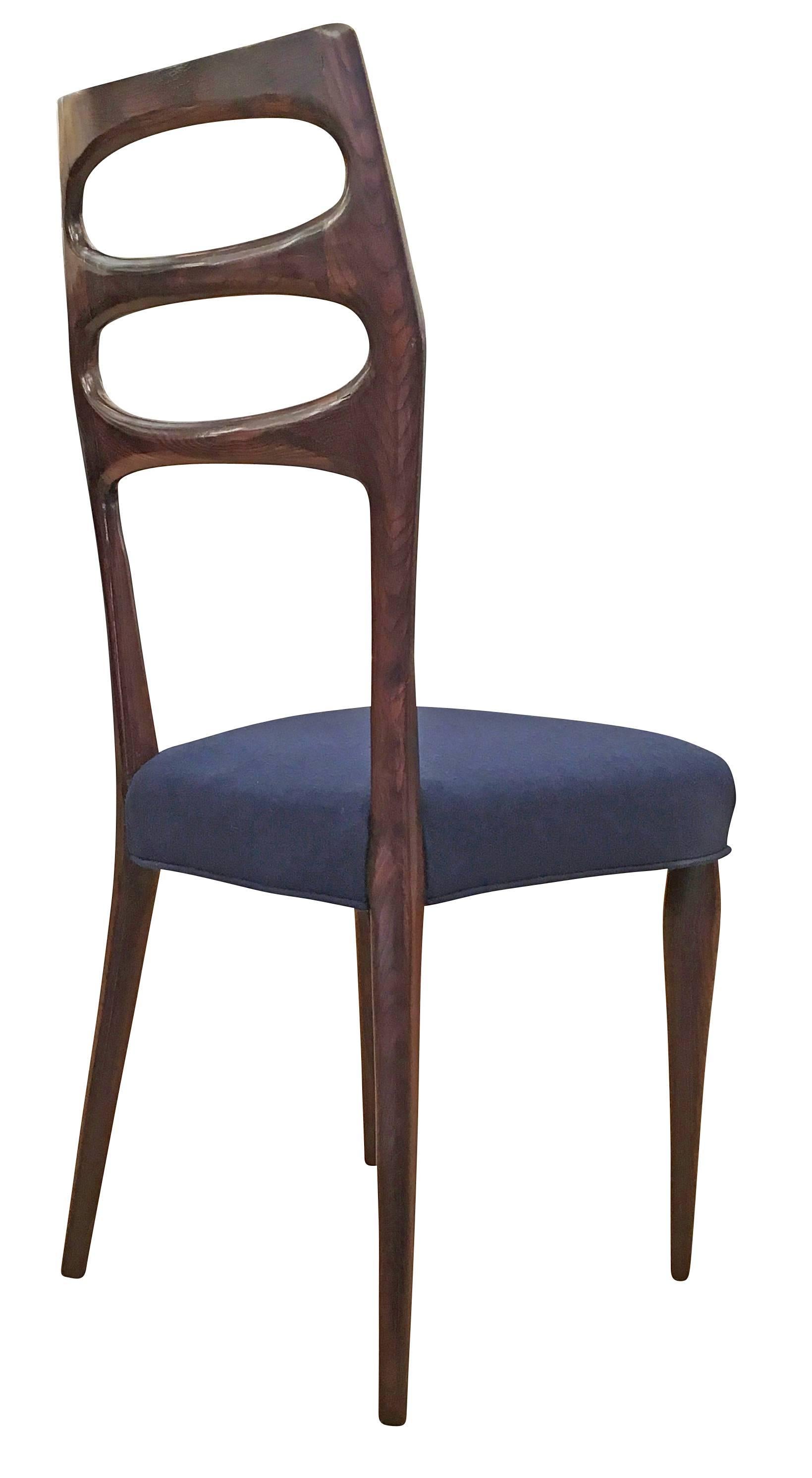 Elegant set of six wooden Italian Mid-century dining chairs. One has been refinished in a dark patina that allows the wood grain to come through and has been upholstered in a dark blue fabric for display purposes. The price includes all the chairs