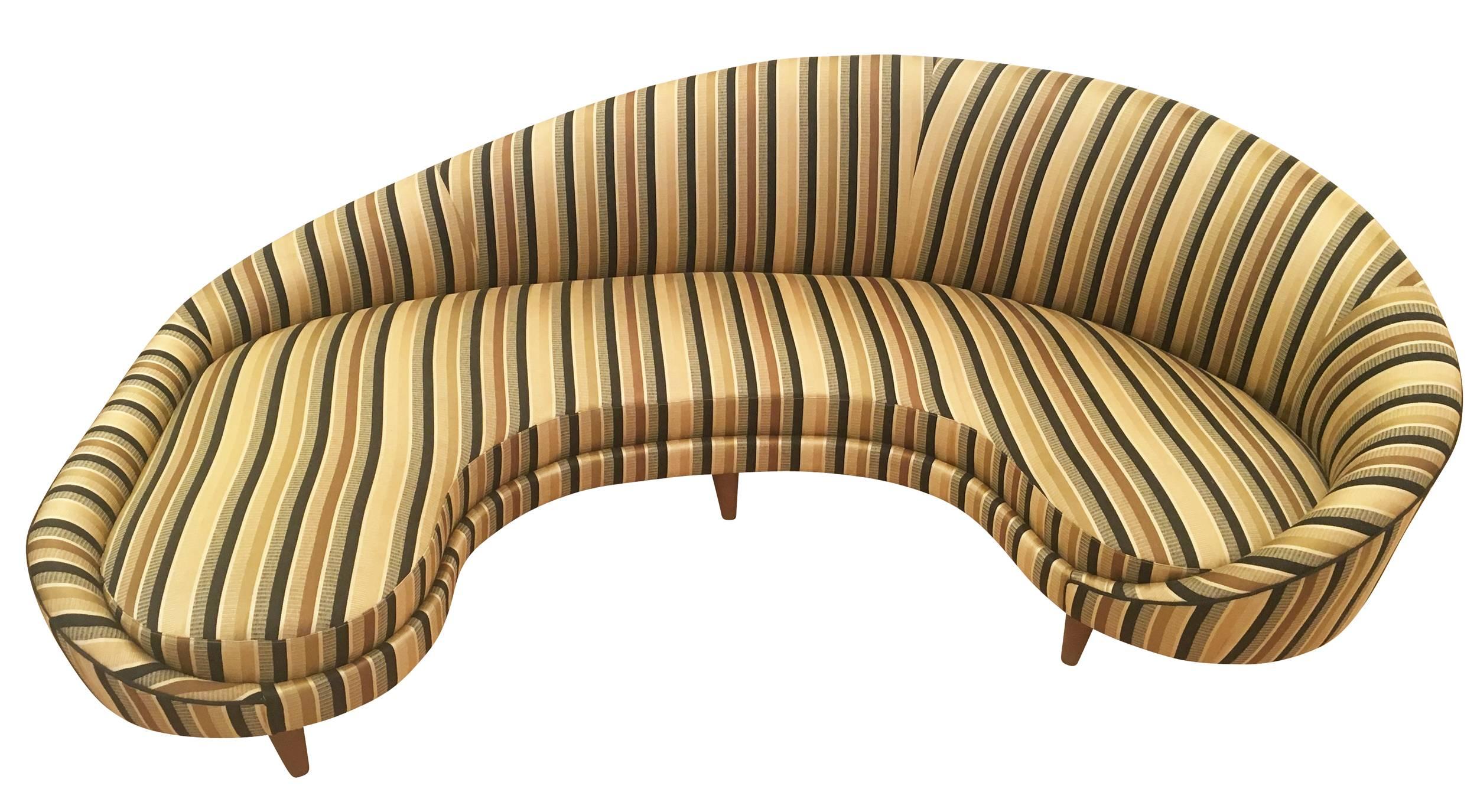 Outstanding curved Italian sofa from the 1960s upholstered in a striped gold fabric. The feet are wood.