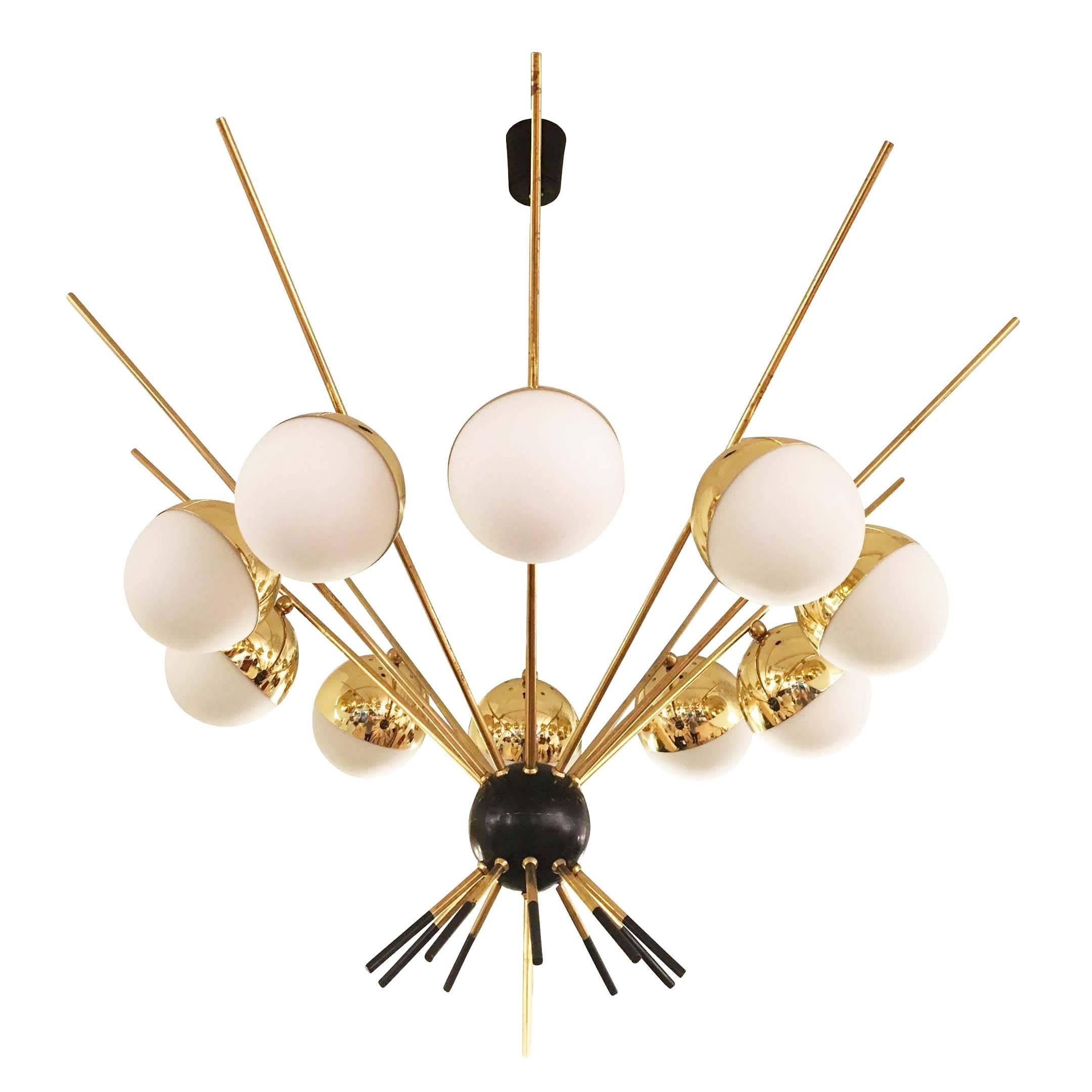 Stunning Italian Mid-Century chandelier by GCME. It features a black lacquered globe from which depart ten long brass arms each holding a frosted glass shade. Smaller arms go downwards from the center globe and have black lacquered tips.

