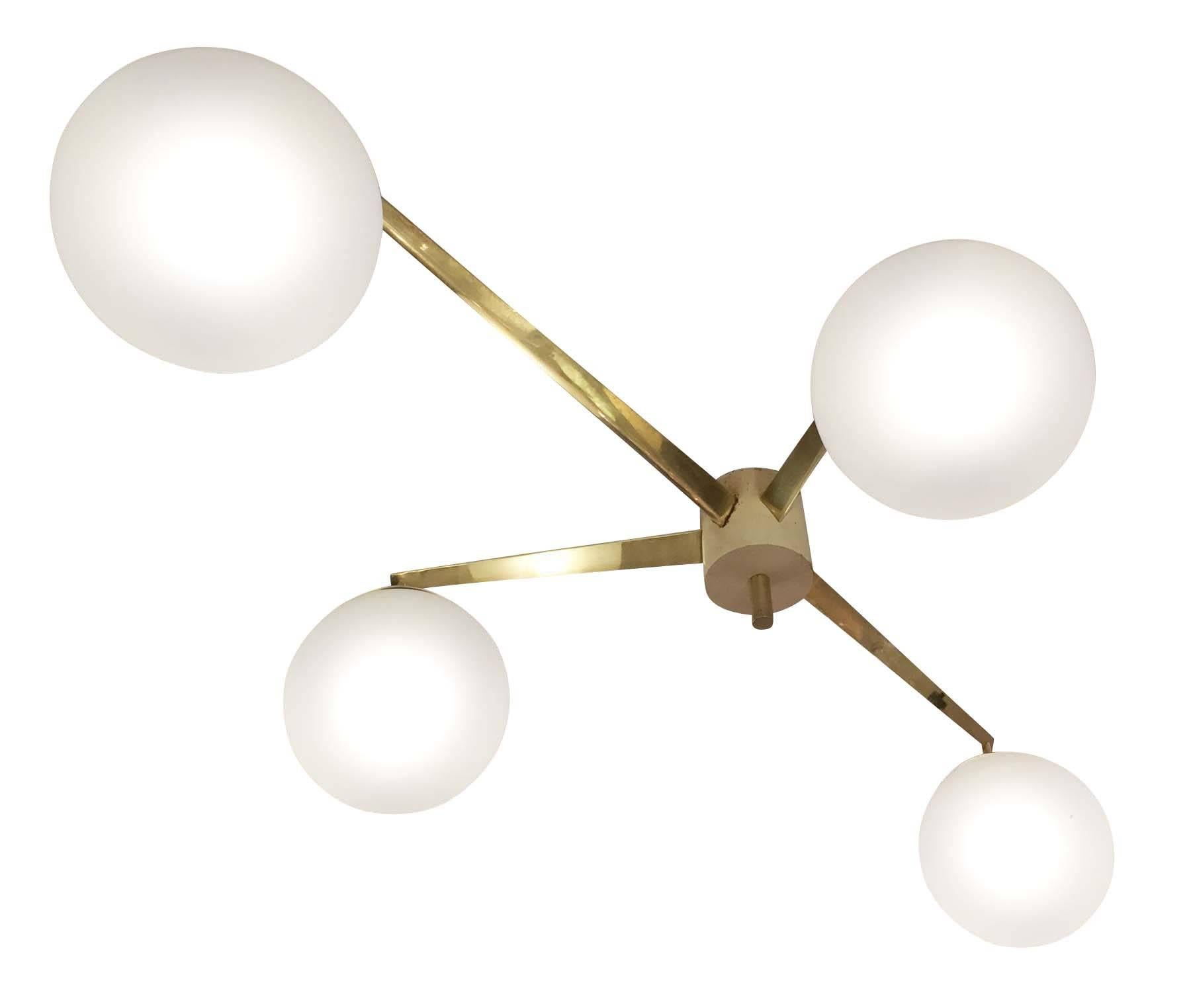 Magnificent rare chandelier designed by Angelo Lelli for Arredoluce in the 1950s. It features four satin globes on an aerodynamic brass frame. The arms are triangular in shape while the center body and globe holders are lacquered white. The original