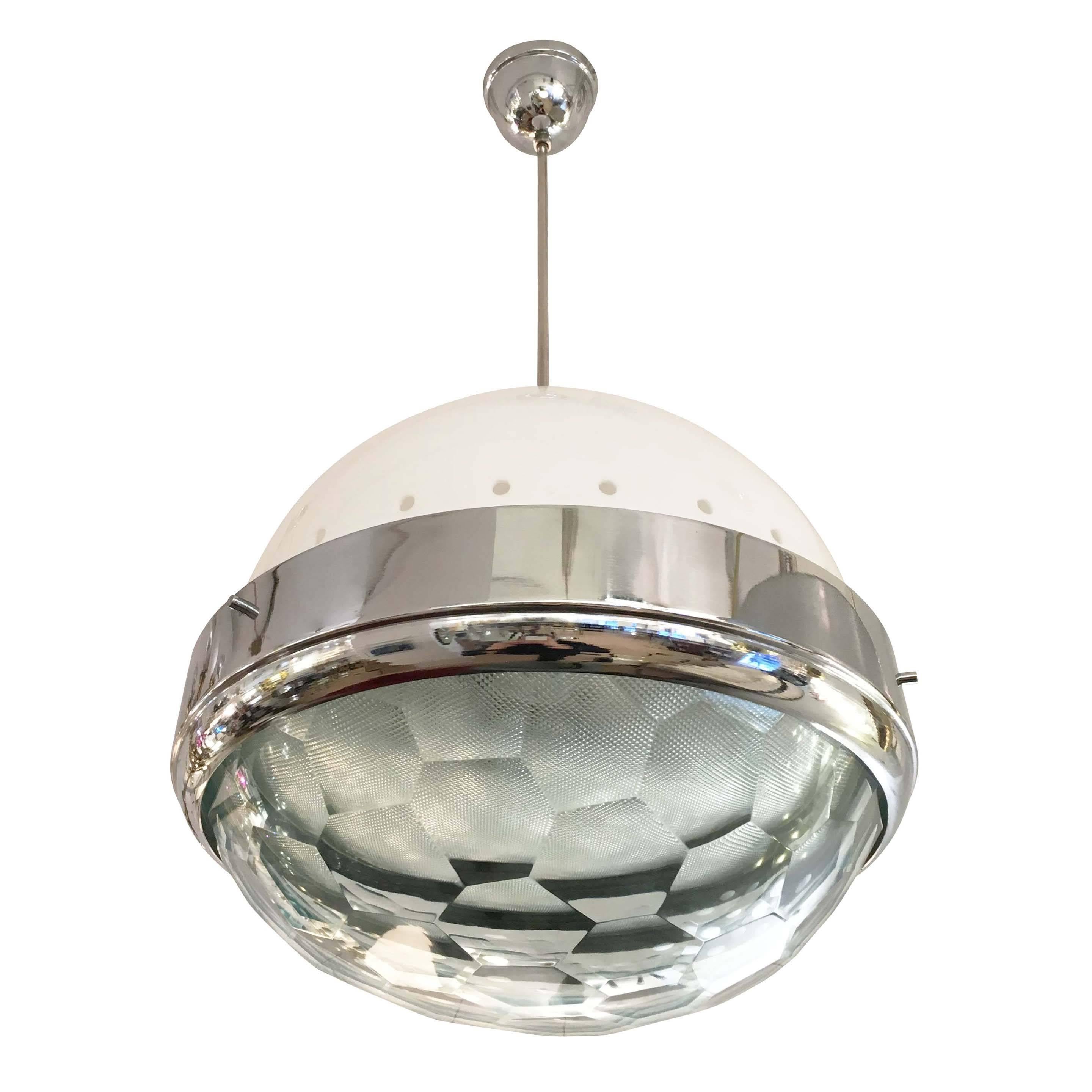 Large pendant attributed to Lumi featuring a faceted glass lens on a chrome frame. There is a second glass lens inside the outer one which helps hide the light bulbs and creates a diffused light. The white perforated canopy is made in Perspex. Holds