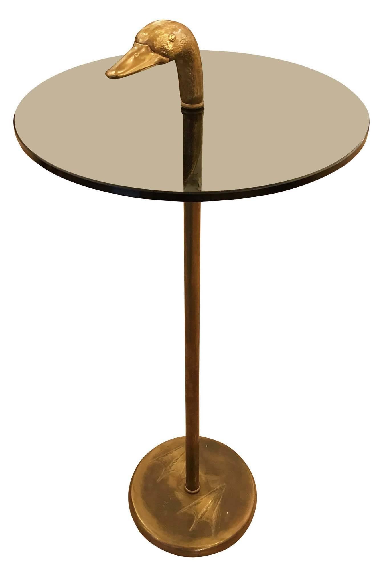 Duck themed side table by Banci, Firenze. The duck head and base with duck feet imprints are bronze while the center stem is brass. The glass is smoked. 
