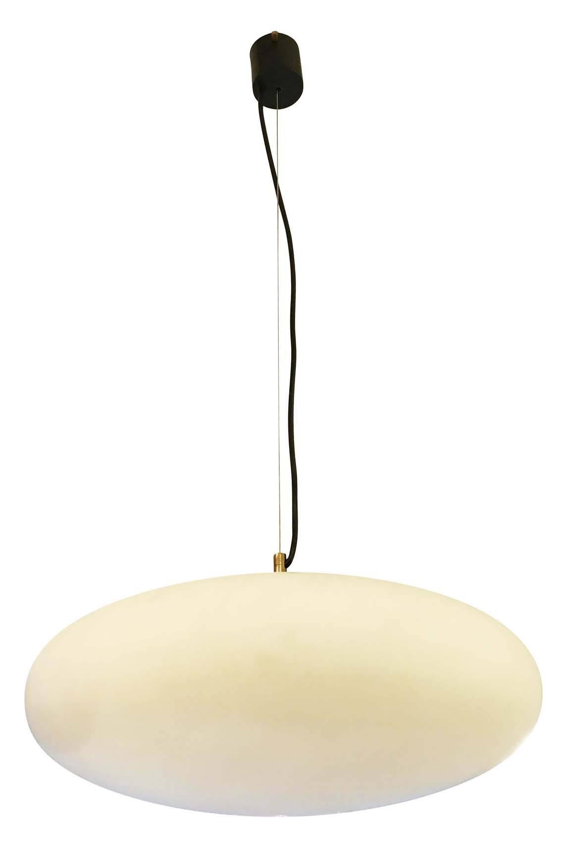 Stilnovo attributed frosted glass pendants with brass and black lacquered hardware. Each holds one regular socket and can be hung on a wire of any length. Three are available which can be sold individually or together to create a breathtaking