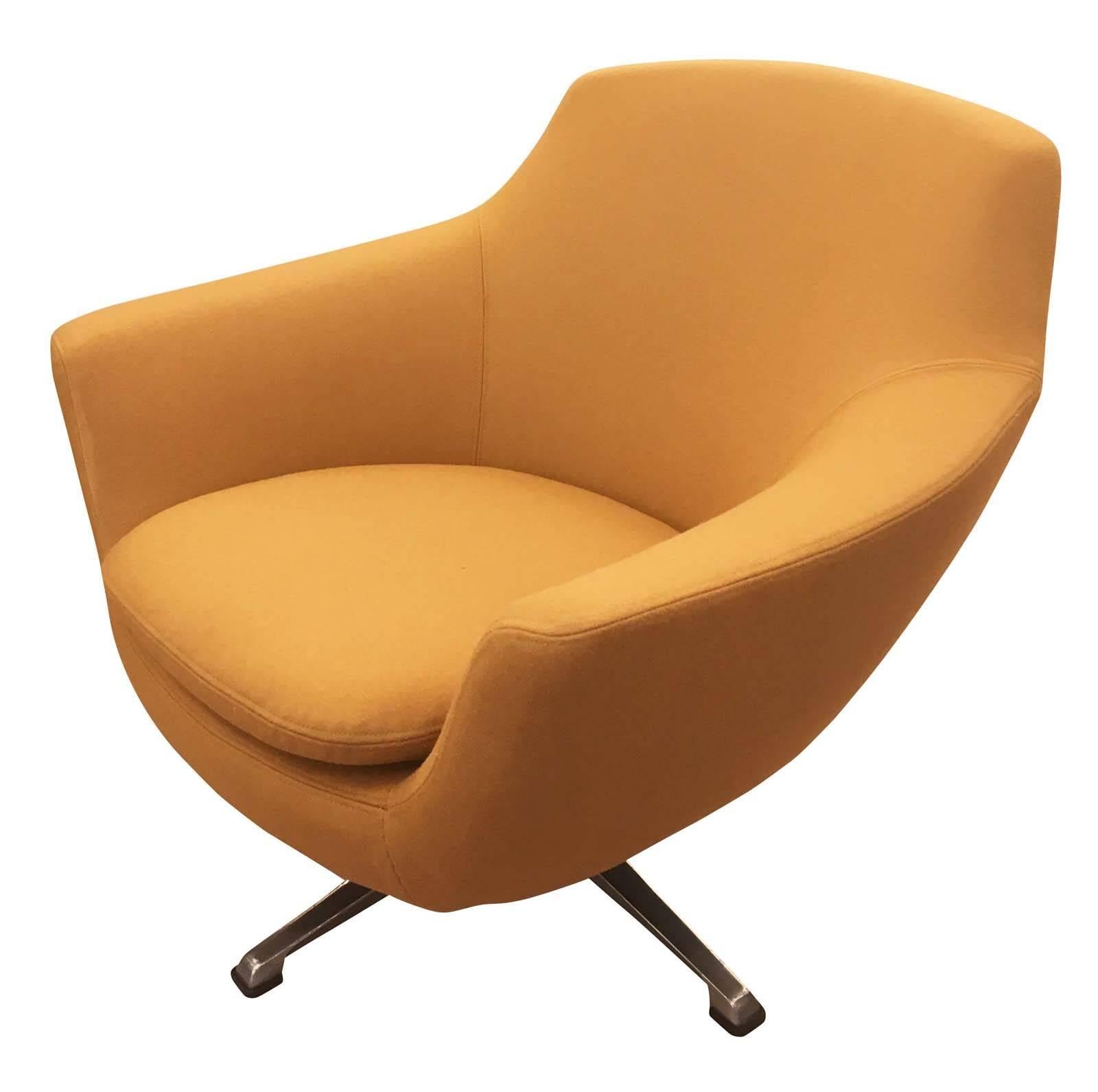 Very comfortable Italian Mid-Century swivel chair with a polished metal base. It has been upholstered in a mustard colored wool fabric.