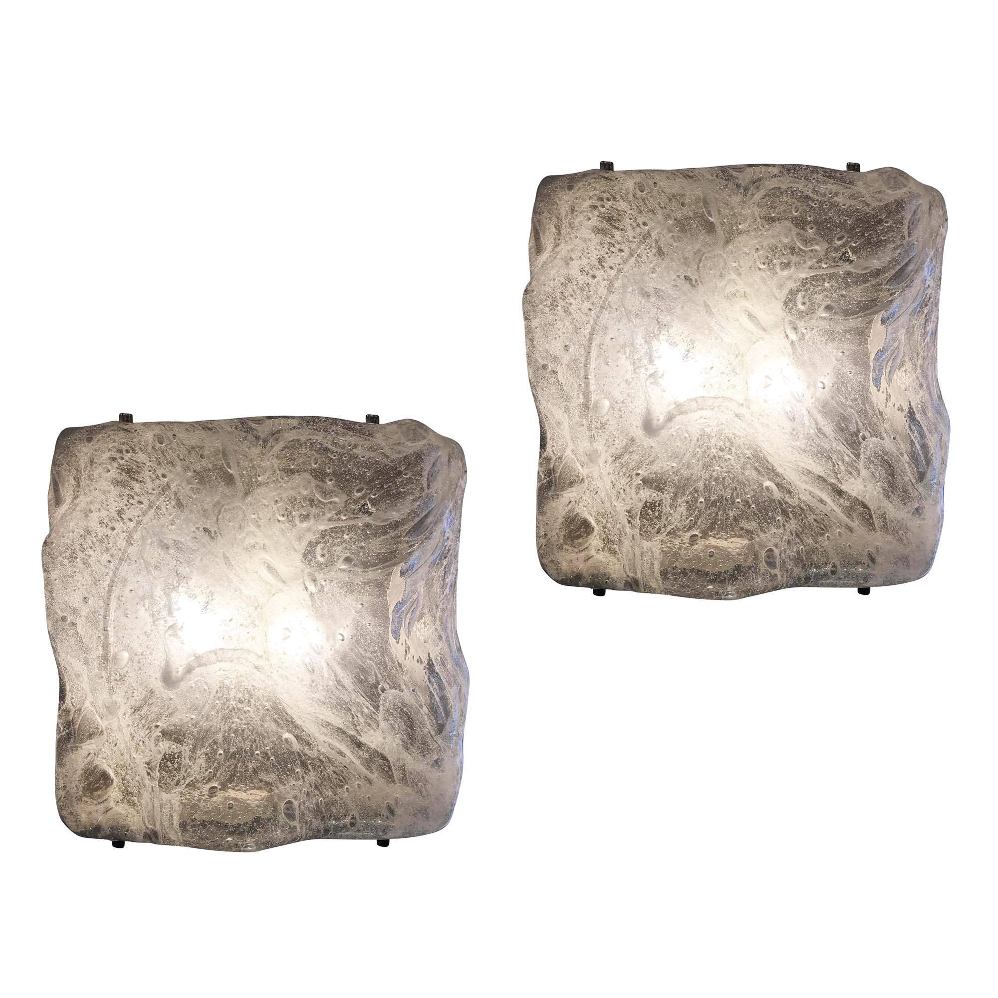Organically styled wall lights made by Poliarte. The undulating clear glass is textured with infused bubbles and white striations. The hardware is metal. Can be also used as flush mount ceiling lights. A single larger one is also available. Price