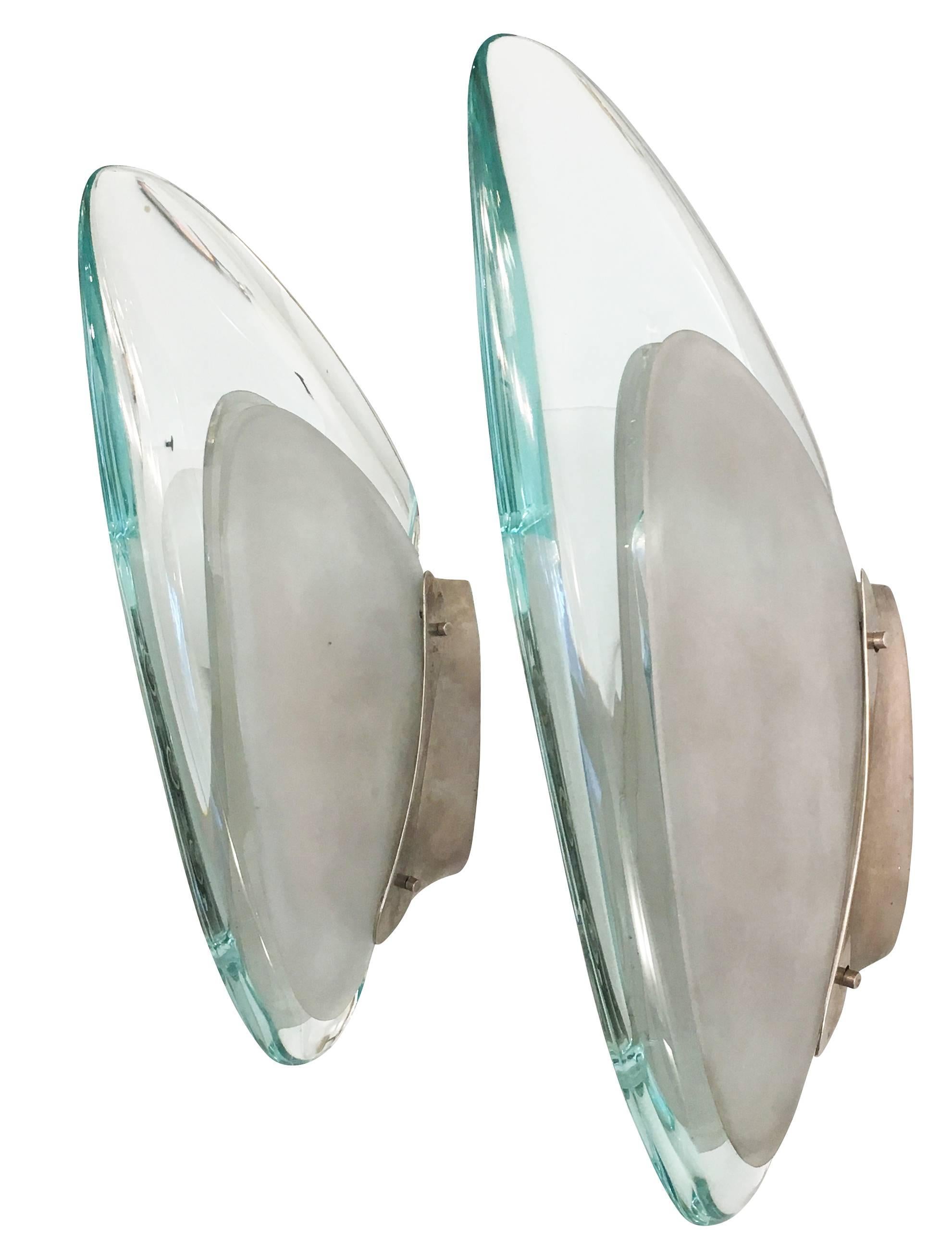 Stunning and rare wall lights model 1552 designed by Max Ingrand in 1956 for Fontana Arte. Each features a central curved glass flanked by two frosted glasses following the same shape. The frame is nickel plated brass and holds three candelabra