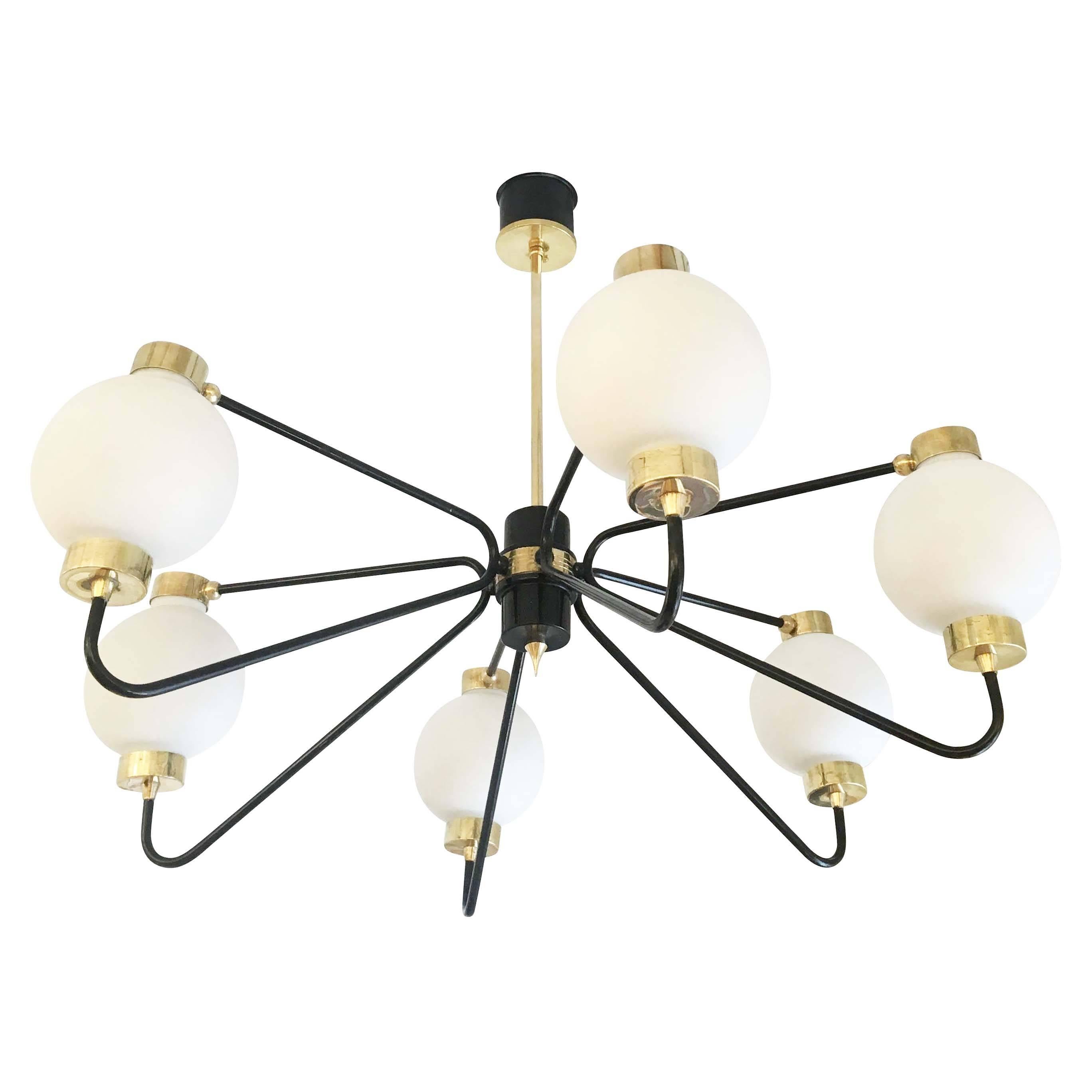 Stilnovo attributed chandelier with six frosted glass shades on a brass and black lacquered frame. Drop can be adjusted as needed. Holds six candelabra sockets. Light bulbs are changed by pulling up the upper arms of the frame and slipping out the