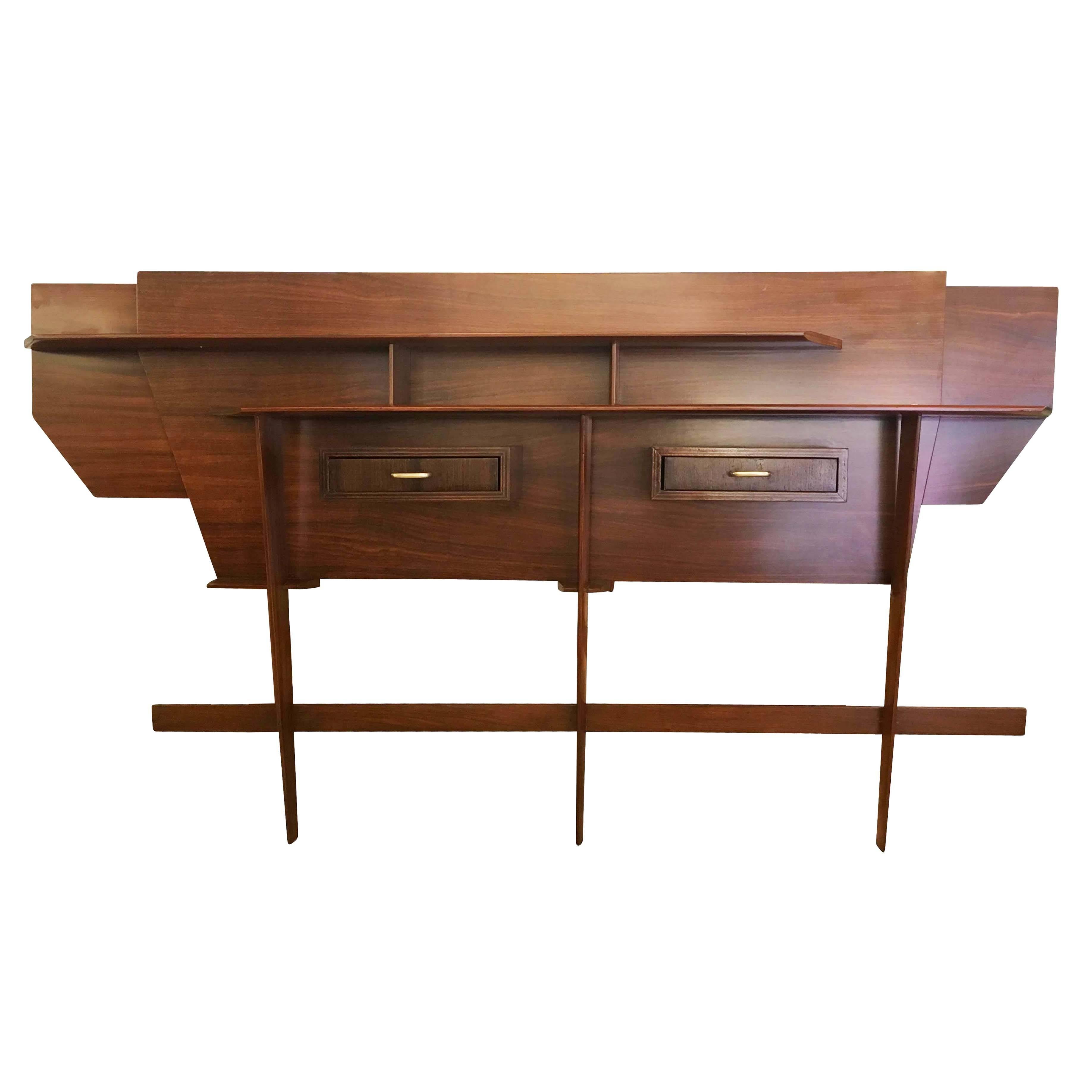 Italian wall console unit perfect for an entry or hallway. Made of wood with brass details, the staggered and tapered components give the piece a sense of movement. Has two drawers.