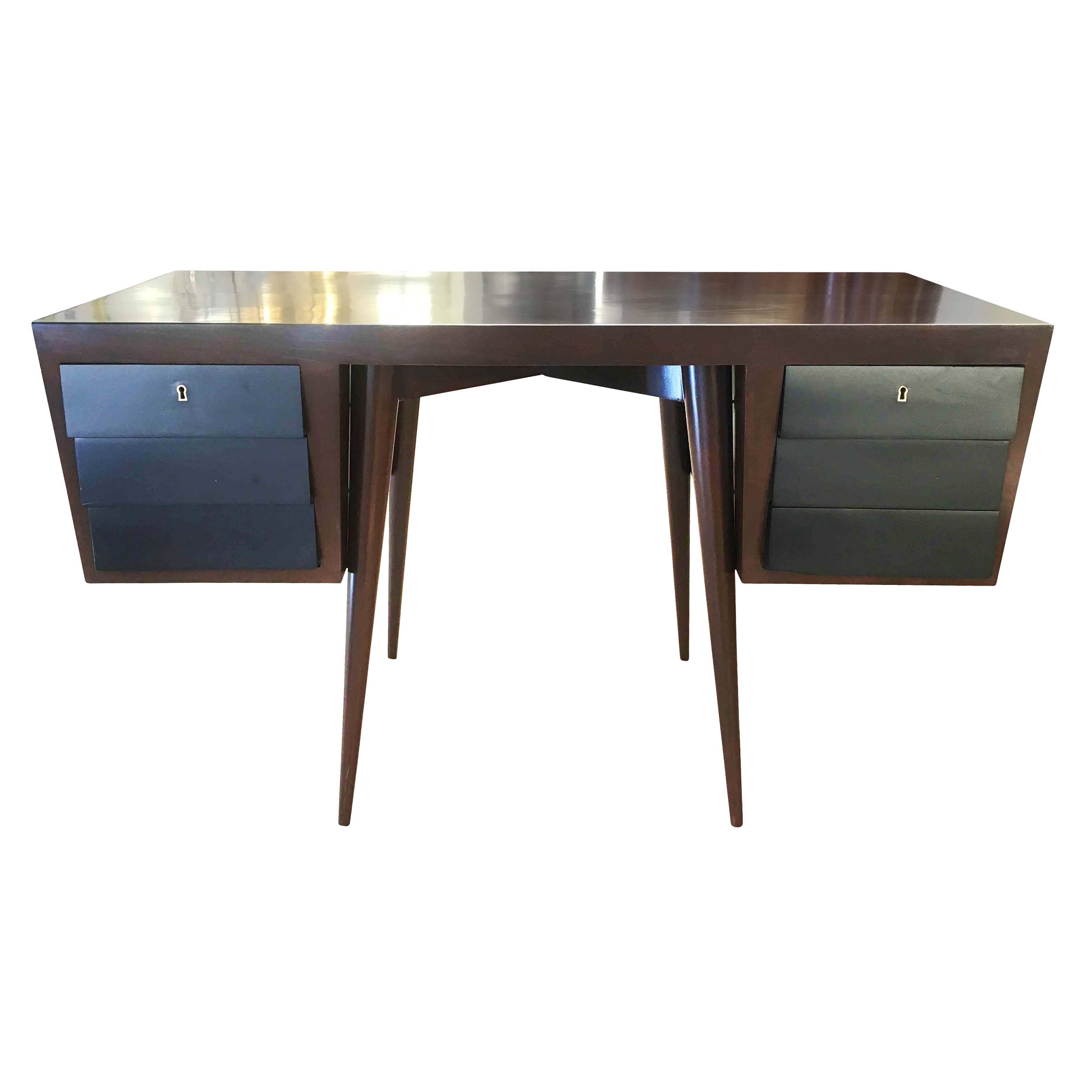 Italian Mid-Century desk refinished in a dark walnut and with ebonized drawers. The crossed legs and staggered drawers show a Scandinavian influence.
