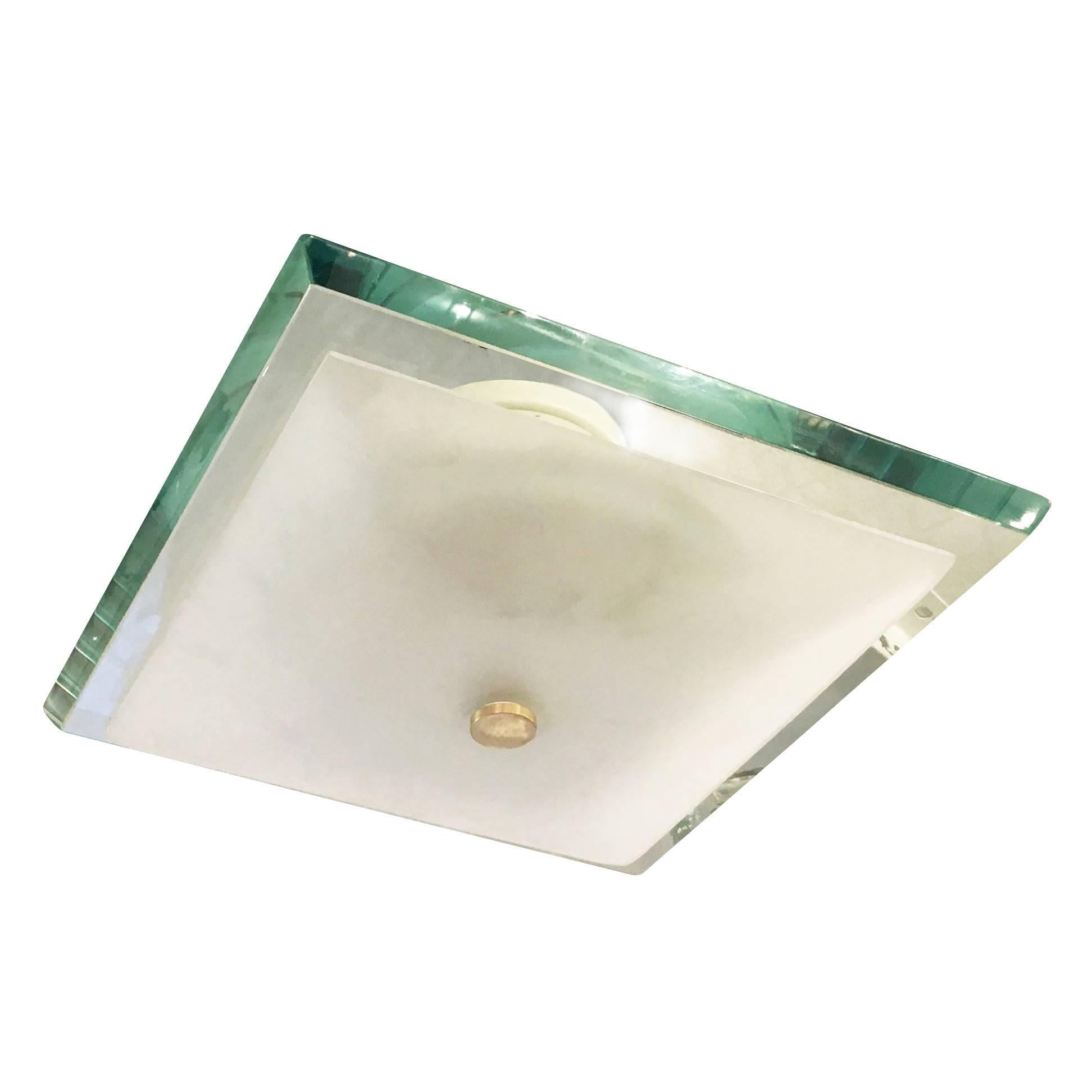 Stunning Fontana Arte flush mount designed by Max Ingrand in the 1960s featuring a thick square glass. As typical of glass of the era it has a green edge which creates a beautiful emerald color when lit or seen from certain angles. The four