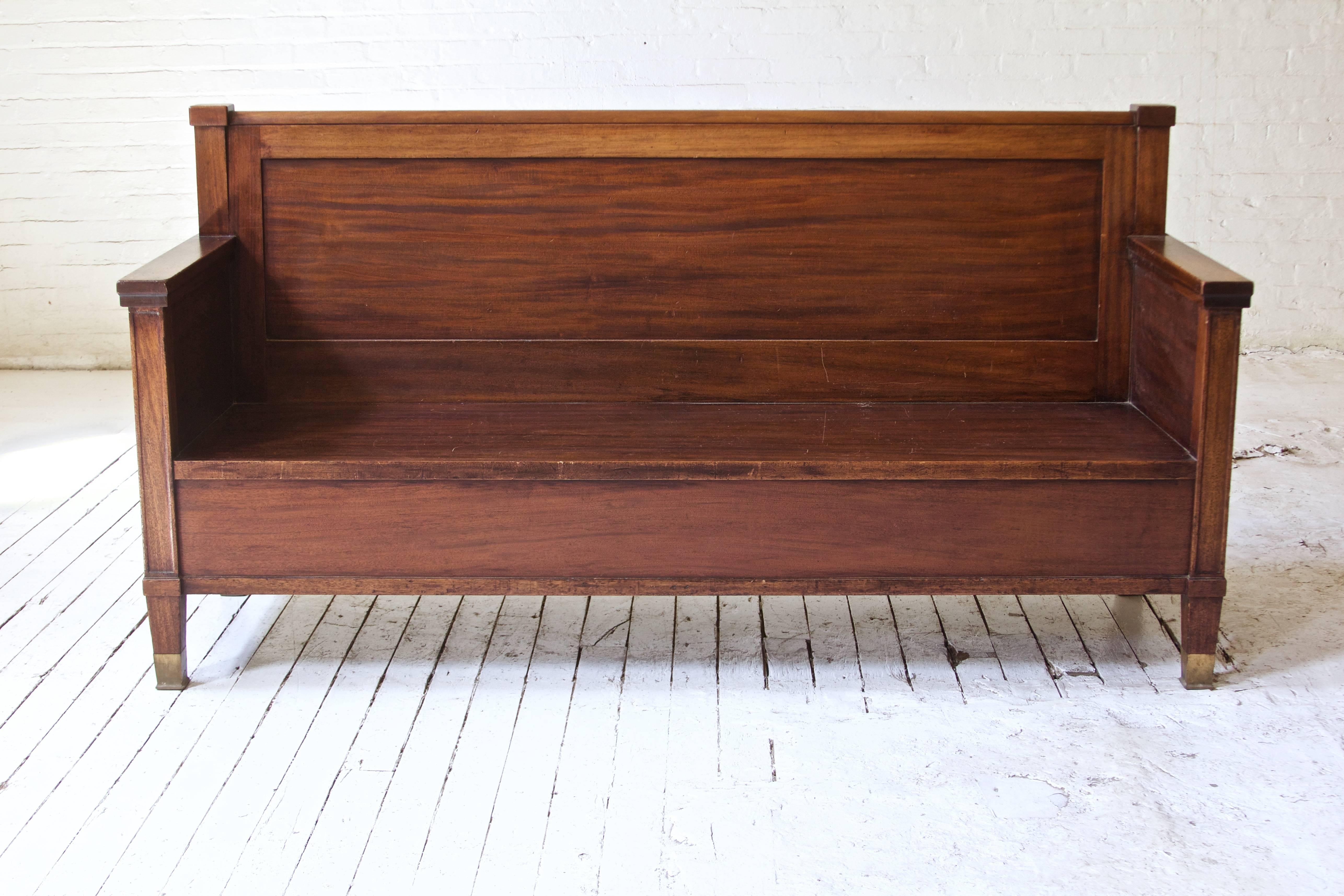Robust antique English bench in highly-figured Cuban Mahogany with brass sabots; in the Gothic Revival style of the late 19th century, circa 1890.