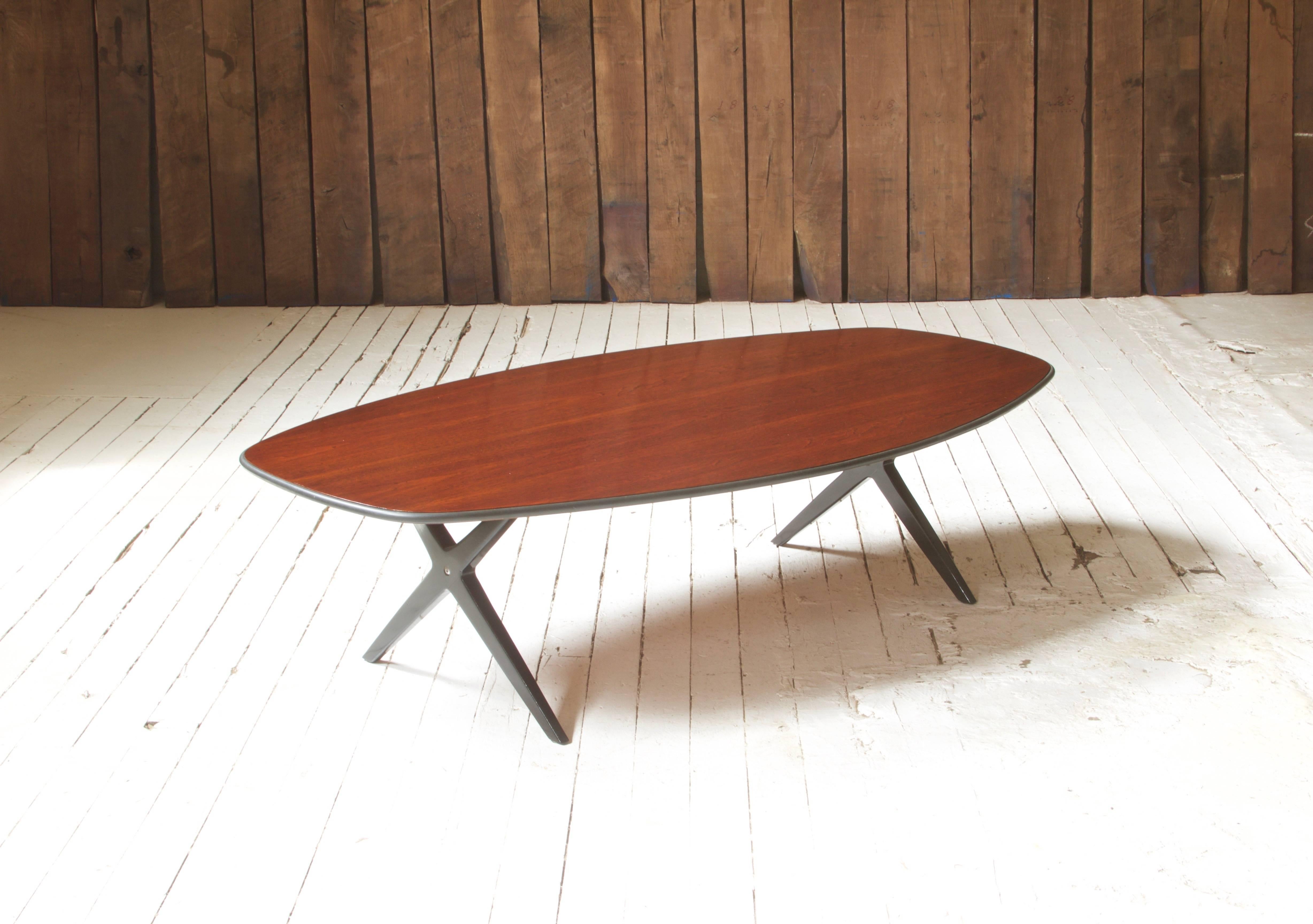 Attractive and practical coffee table of unusual form by George Nelson for Herman Miller featuring richly polished rosewood top with rubber bump-guard. 'Double-X' base of black lacquered wood with steel-tube supports; item is in very good vintage