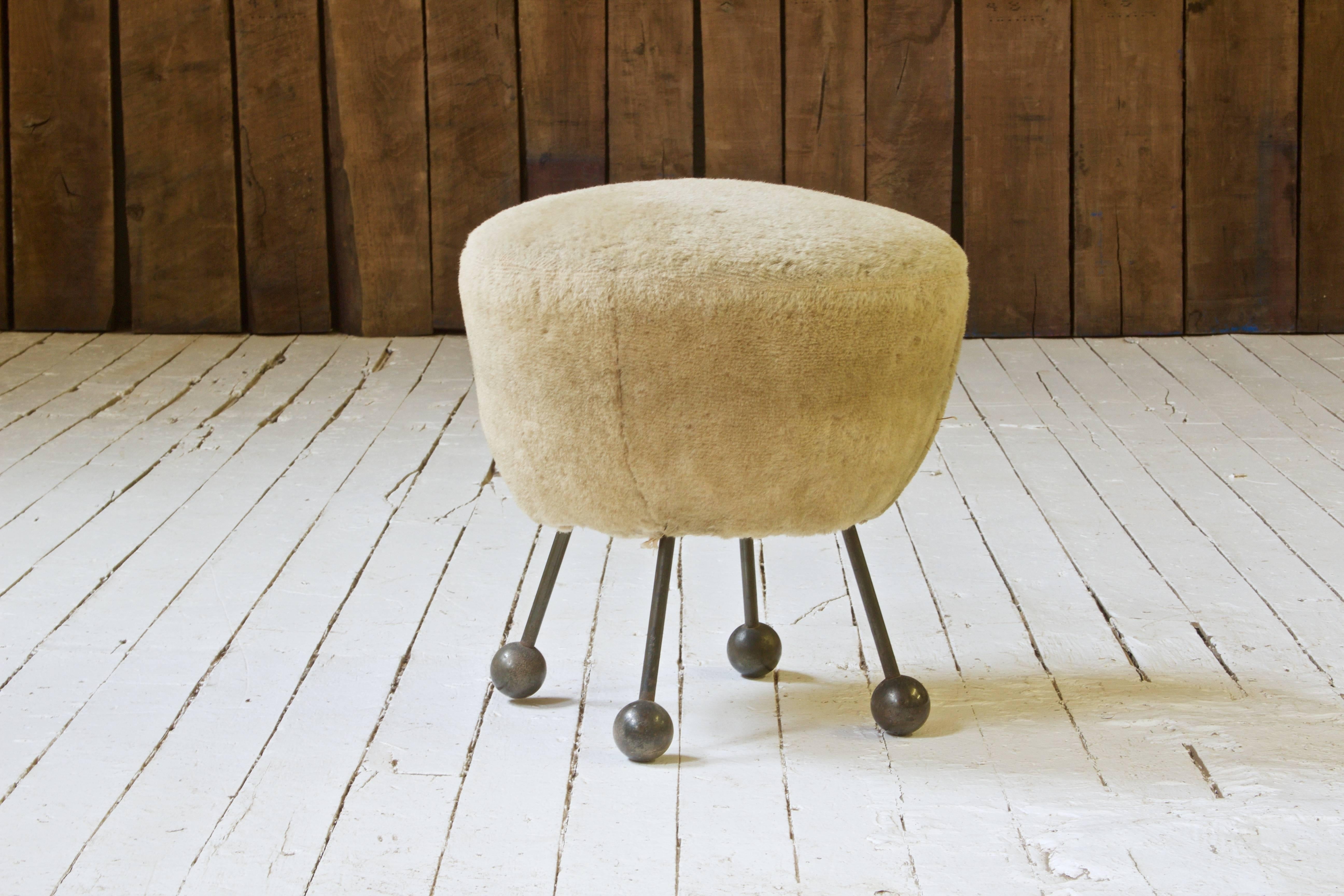 Extremely rare faux fur upholstered pouf with hammered bronze ball feet attributed to Jean Royere. This piece shares many similarities with designs conceived within Royere's 