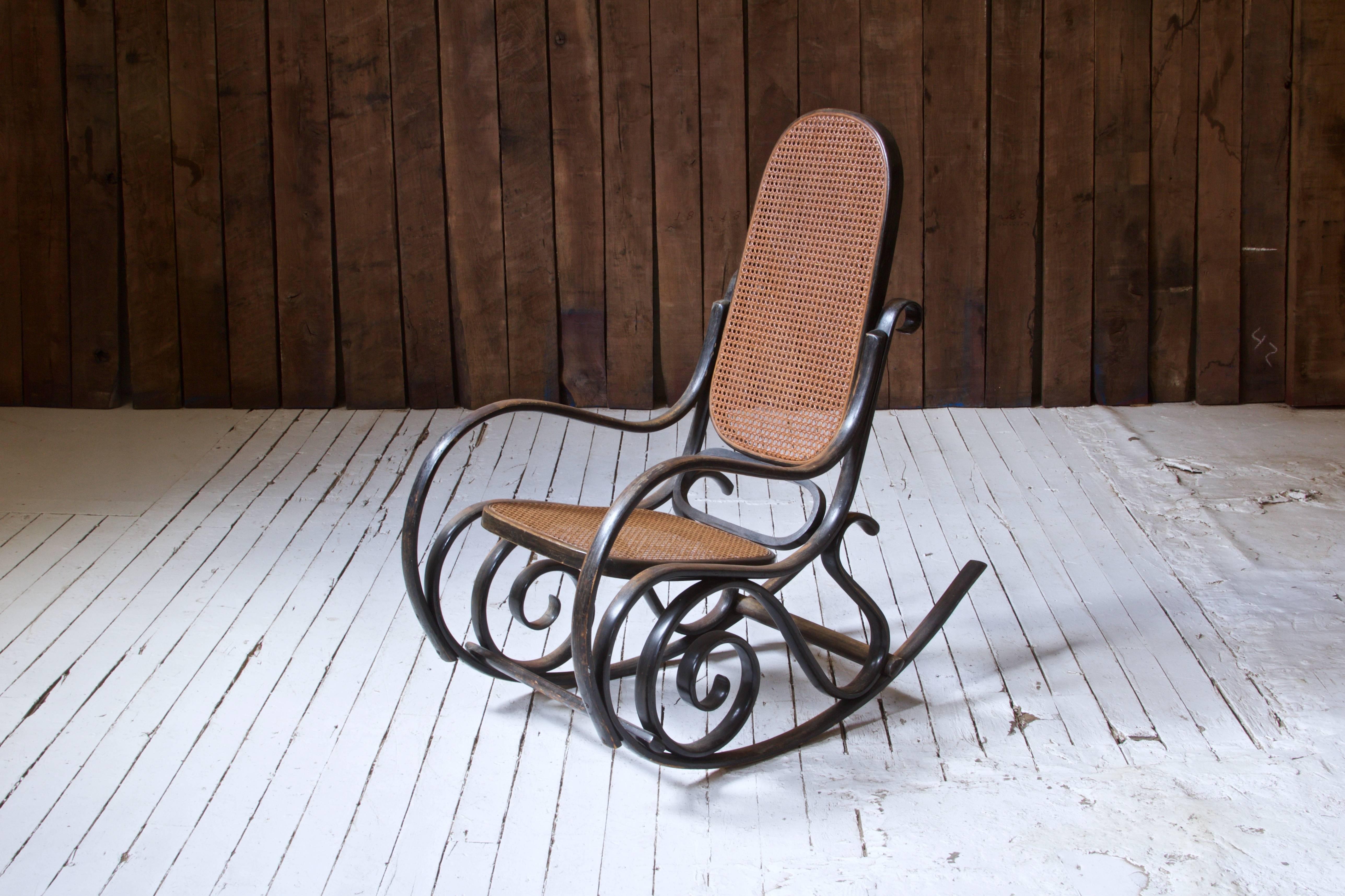 This design, the Thonet Model #10, is an iconic curvilinear rocking chair first conceived by the prolific Michael Thonet in the mid/late 19th century. Thonet efficiently outsourced production of many of his designs throughout the 19th and 20th