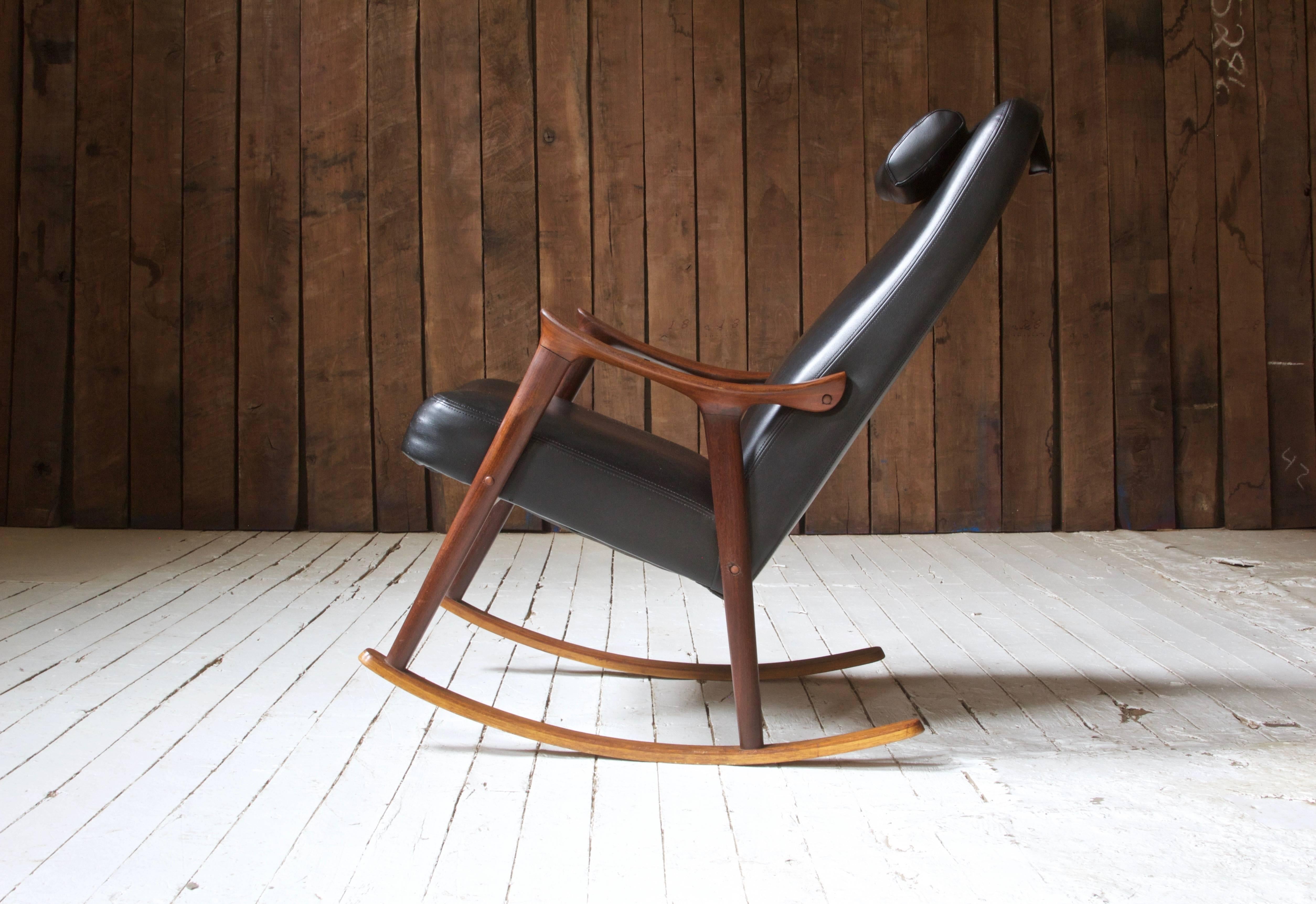 Attractive and comfortable teak and black vinyl rocking chair in original vintage condition by Ingmar Relling for Westnofa, Norway. This design features lovely sculpted arms and a removable counter-weighted headrest.
