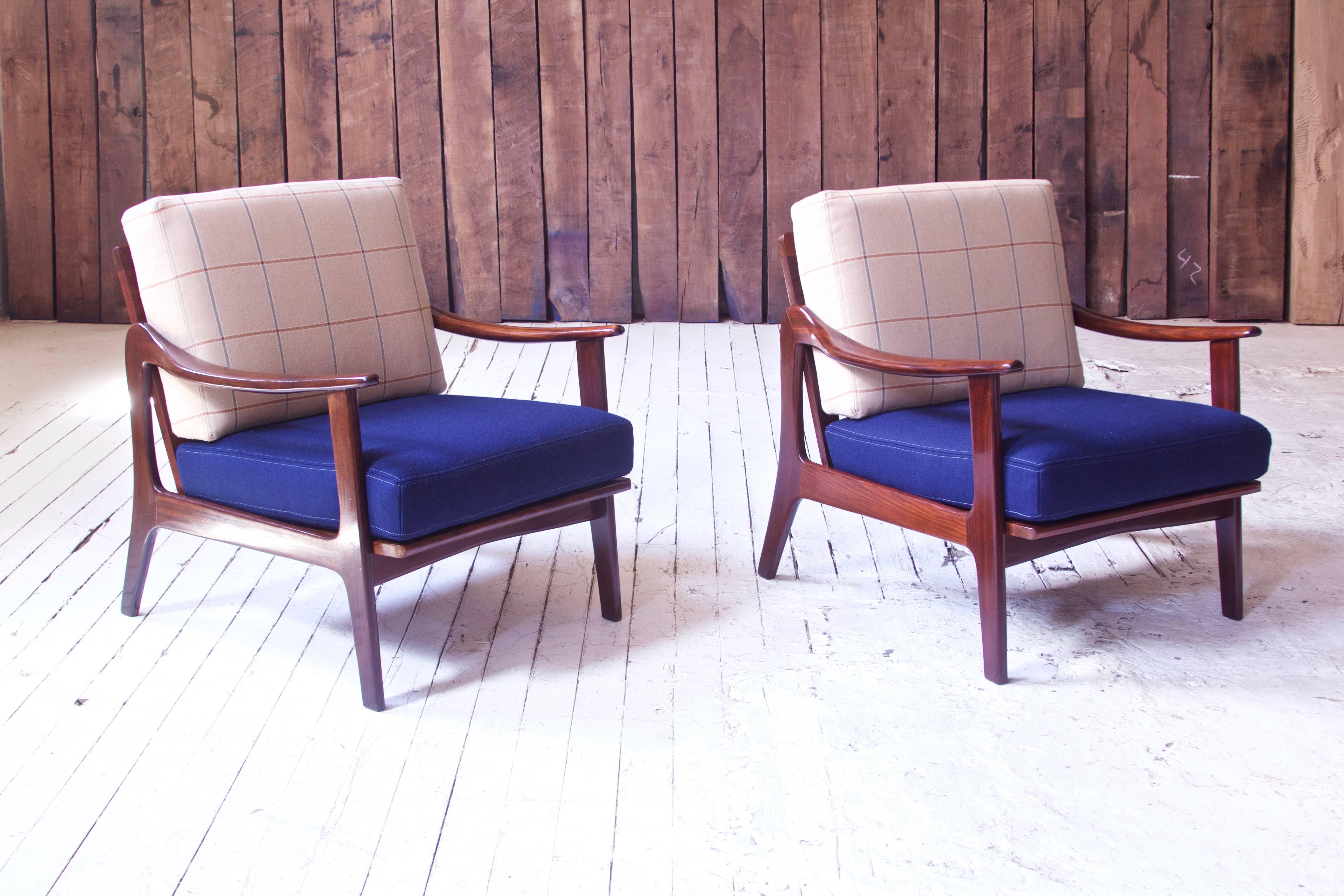 Rare pair of sculpted teak lounge chairs by Norwegian-born furniture designer Fredrik A. Kayser; manufactured by Vatne Mobler in Norway, circa 1955. The chairs' cushions have been redone in royal blue and light plaid wool, frames reconditioned and