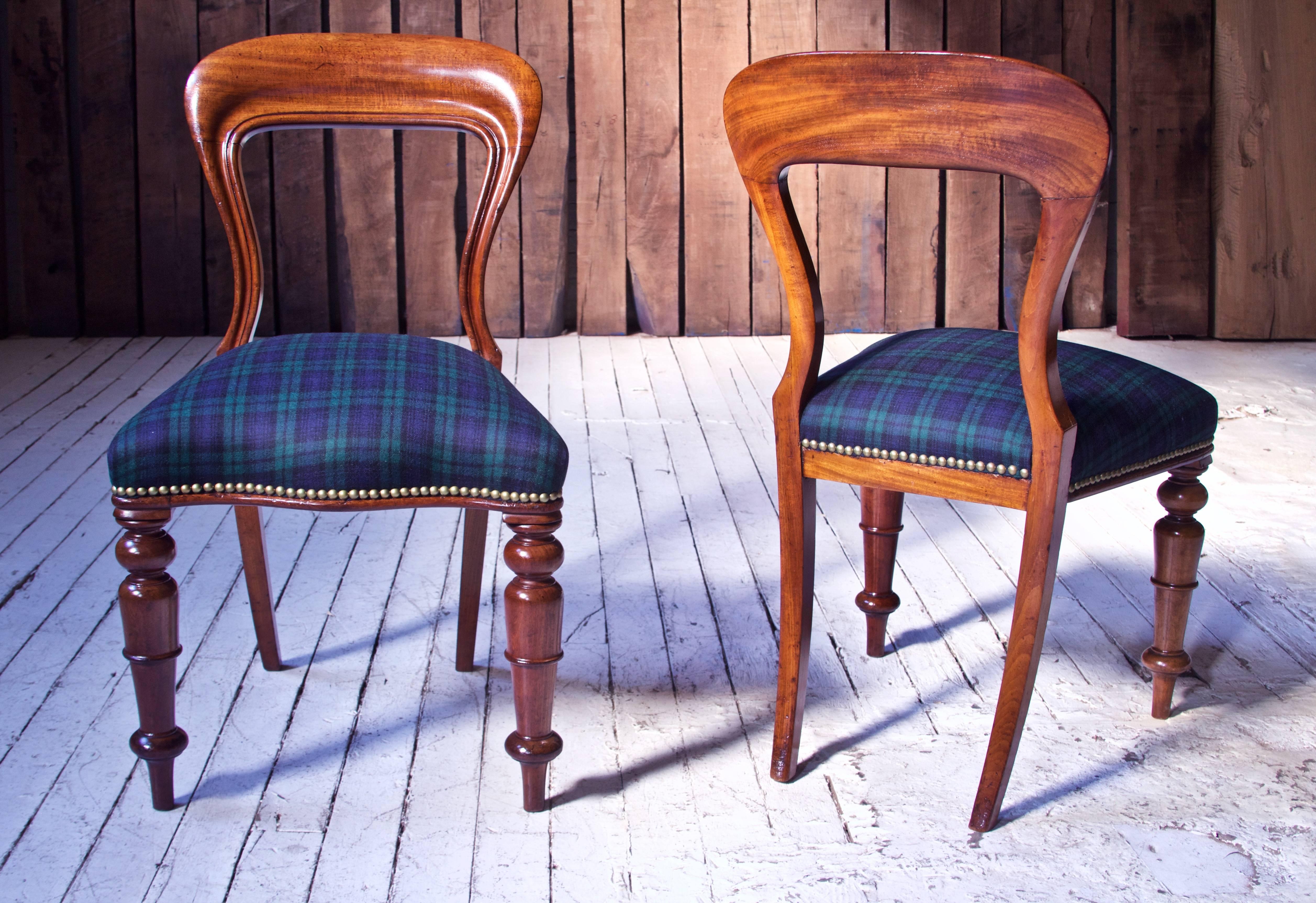 Gorgeous set of likely Irish early-mid 19th century 'Balloon' back dining chairs in carved and moulded well-figured Cuban mahogany with splayed saber back legs and tapering spindle-turned front legs over pegged feet. Serpentine stuff-over seats have