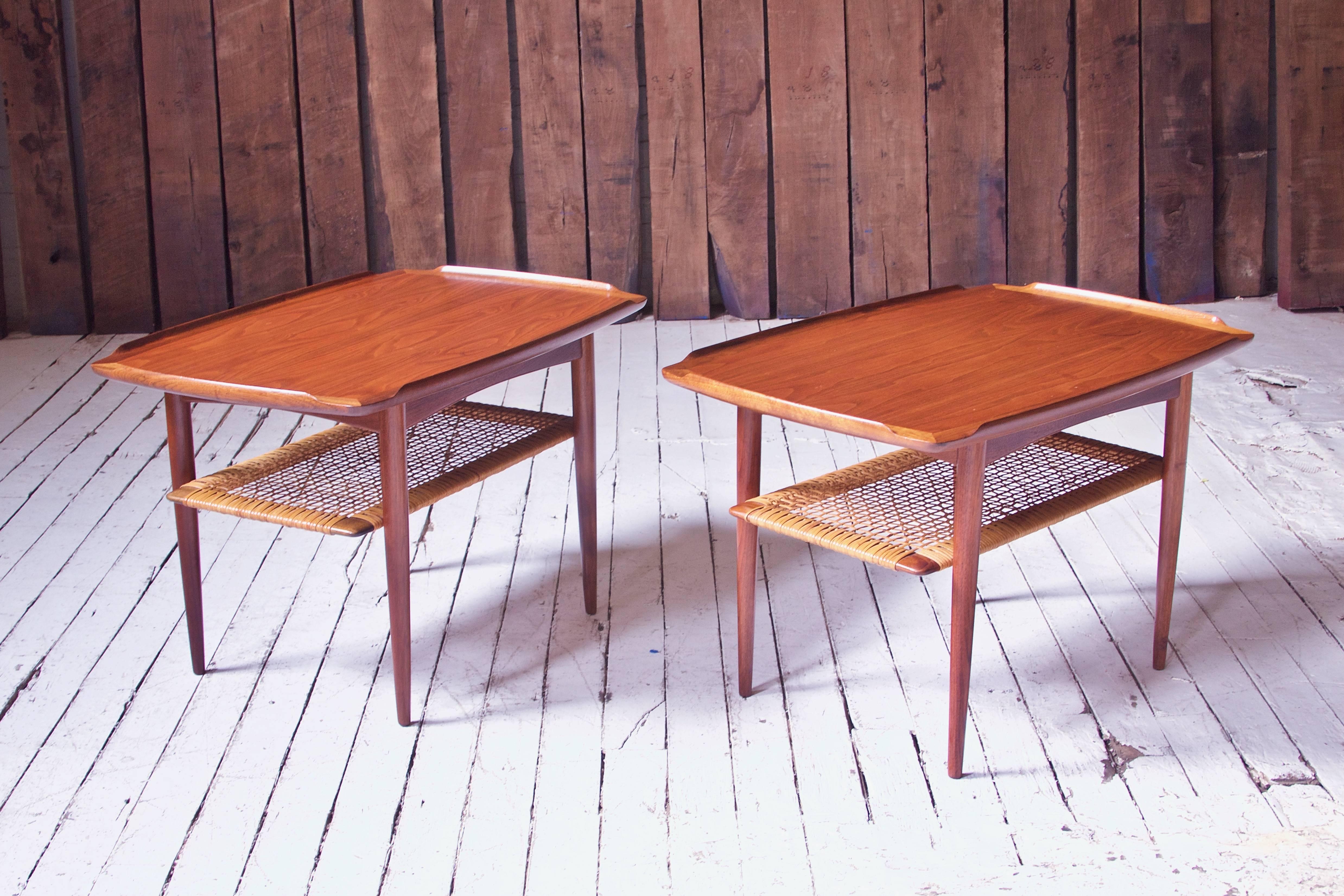 Attractive pair of bookmatched, figured teak and cane side tables by Poul Jensen for Selig, circa 1965. Useful design features a woven cane magazine level below joined top with shaped gallery. Good craftsmanship, great selection and tone to teak