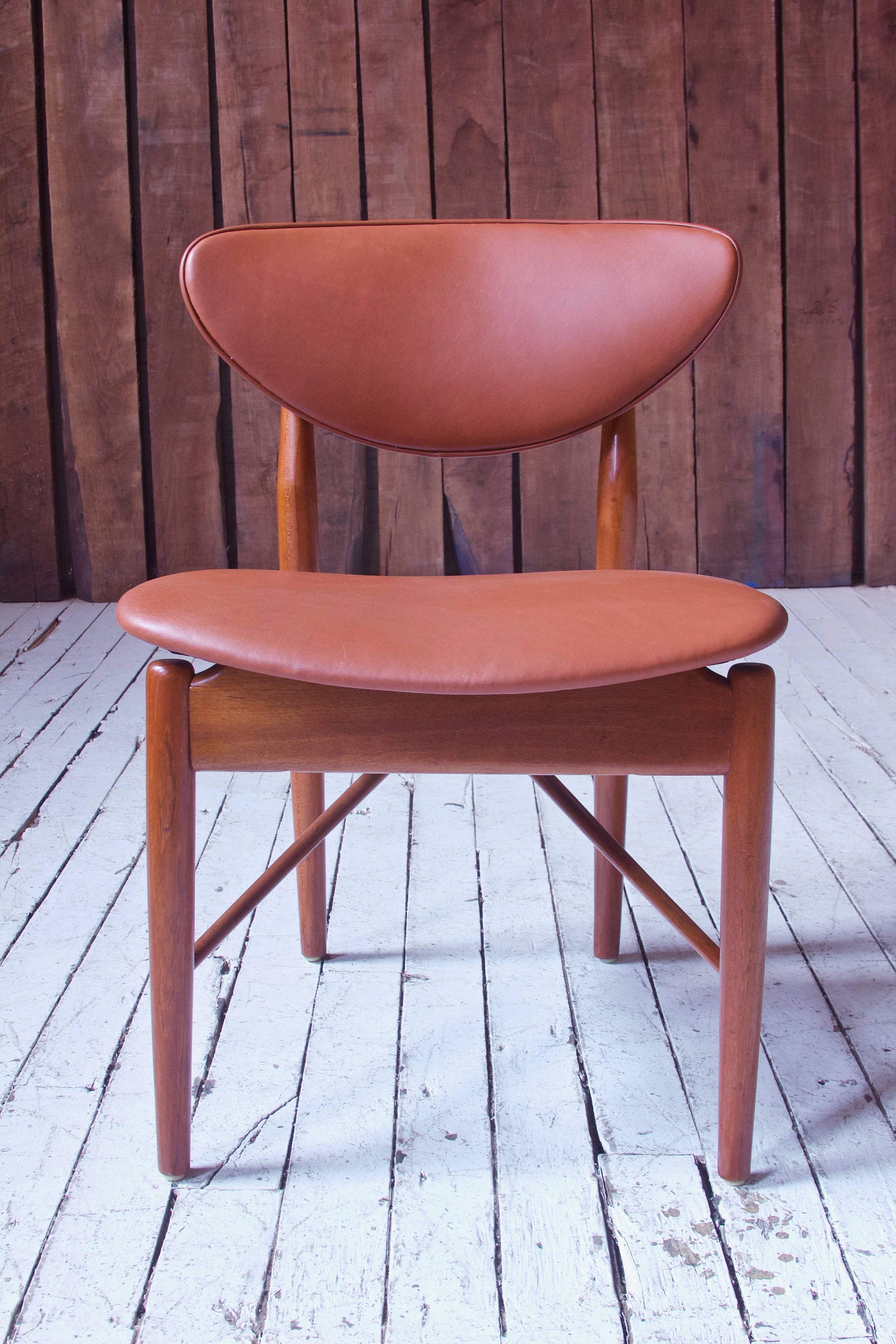 Sophisticated side chair Model-108 (designed in 1946) in teak and leather by the venerable Finn Juhl (1912-1989). Outstanding ergonomics make this petite chair one of the most comfortable seats we've come across; and the experimental engineering of