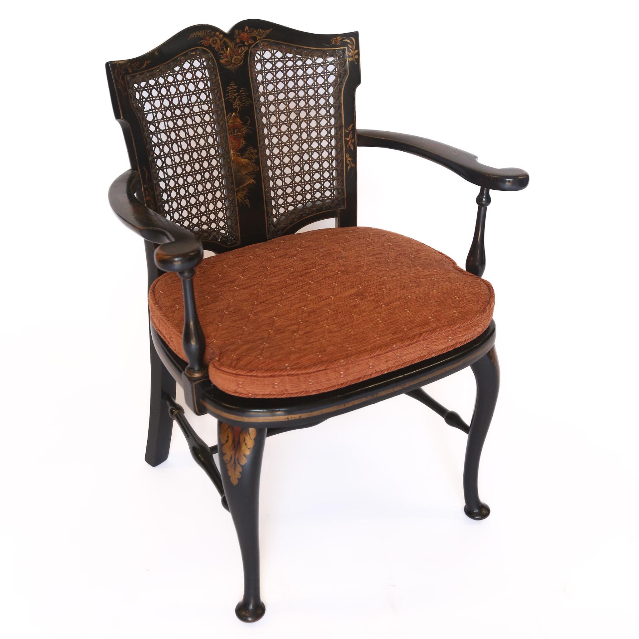 Chaise coudée décorée de Chinoiserie circa 1930
Couleur noir et or, 
Jumelles  panneau arrière canné avec décoration Chinoiserie Centre
Représentation d'une maison, d'arbres et de feuillages
Paire de coudes ouverts
Siège canné, avec récent  Coussin