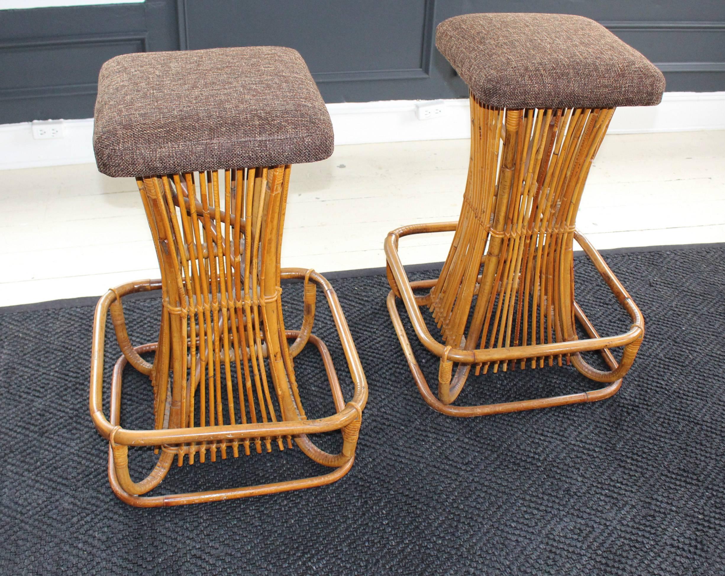 Pair of rattan Franco Albini stools, 1950s, Italy, with generous footrest and newly upholstered perch in a brown tweed with a Mid-Century feel.
