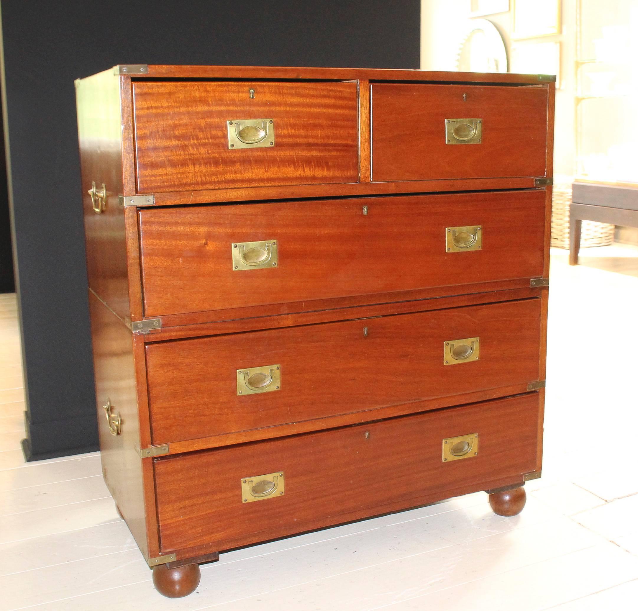 Five-drawer Campaign chest, 19th century England, in two parts on bun feet with recessed brass drawer pulls and corner hardware.