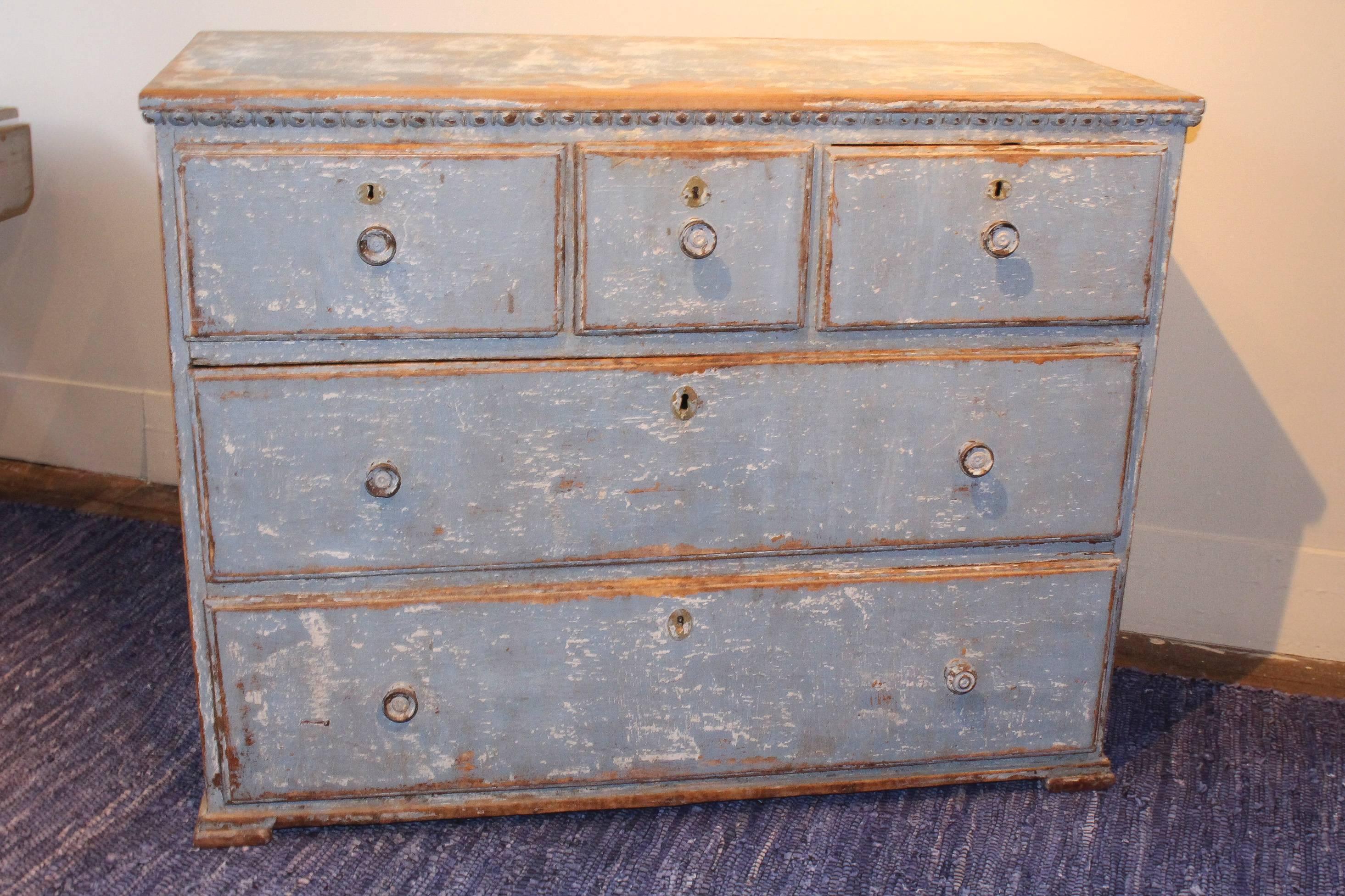 Painted chest, 19th century Portugal, with three smaller side-by-side drawers over two full-length drawers, all with self knob pulls. Chest is in original blue paint with distressed appearance that shows its age. Unusual moulding and stepped feet