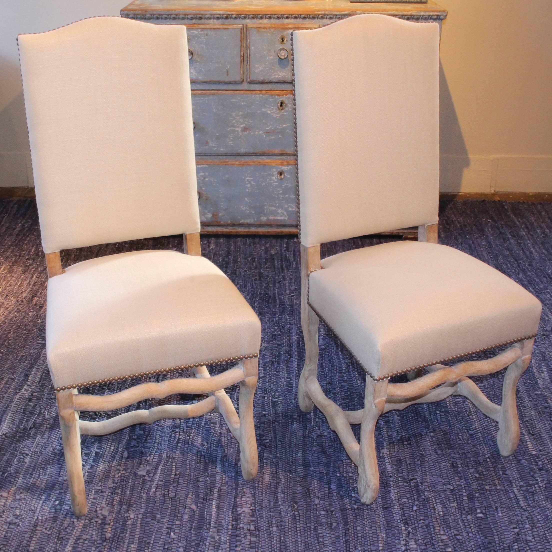 Set of eight Os de Mouton dining chairs, early 20th Century, France, on bleached wood frames with new neutral linen upholstery.  A pair of matching armchairs is also available.