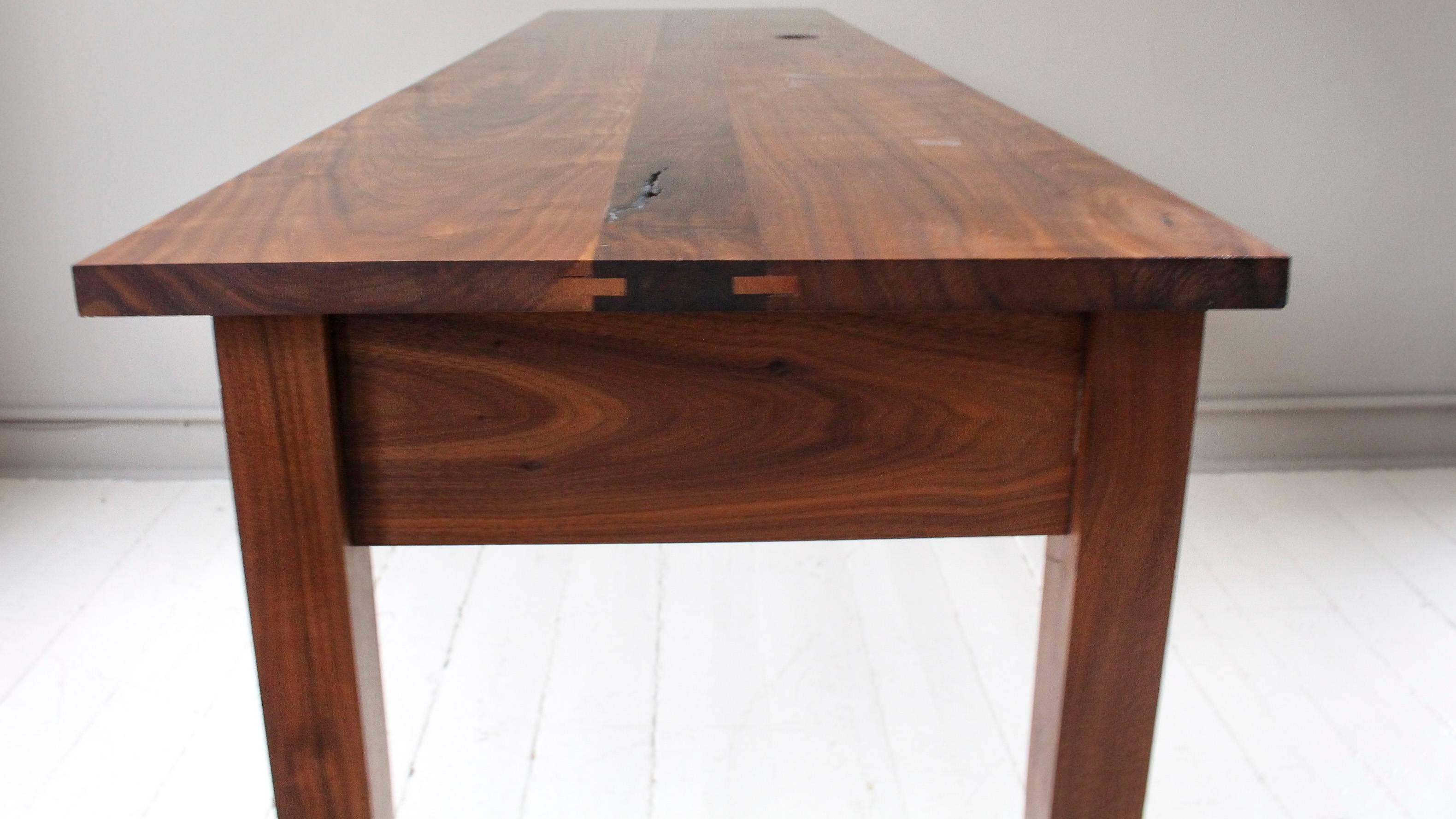 Handmade One-of-a-Kind Walnut Console Table, 21st century American, with custom finish. Table, which is constructed with nary a nail nor dab of glue, has a missing loose knot on the surface that adds to its artisan charm. Raised on tapering legs,