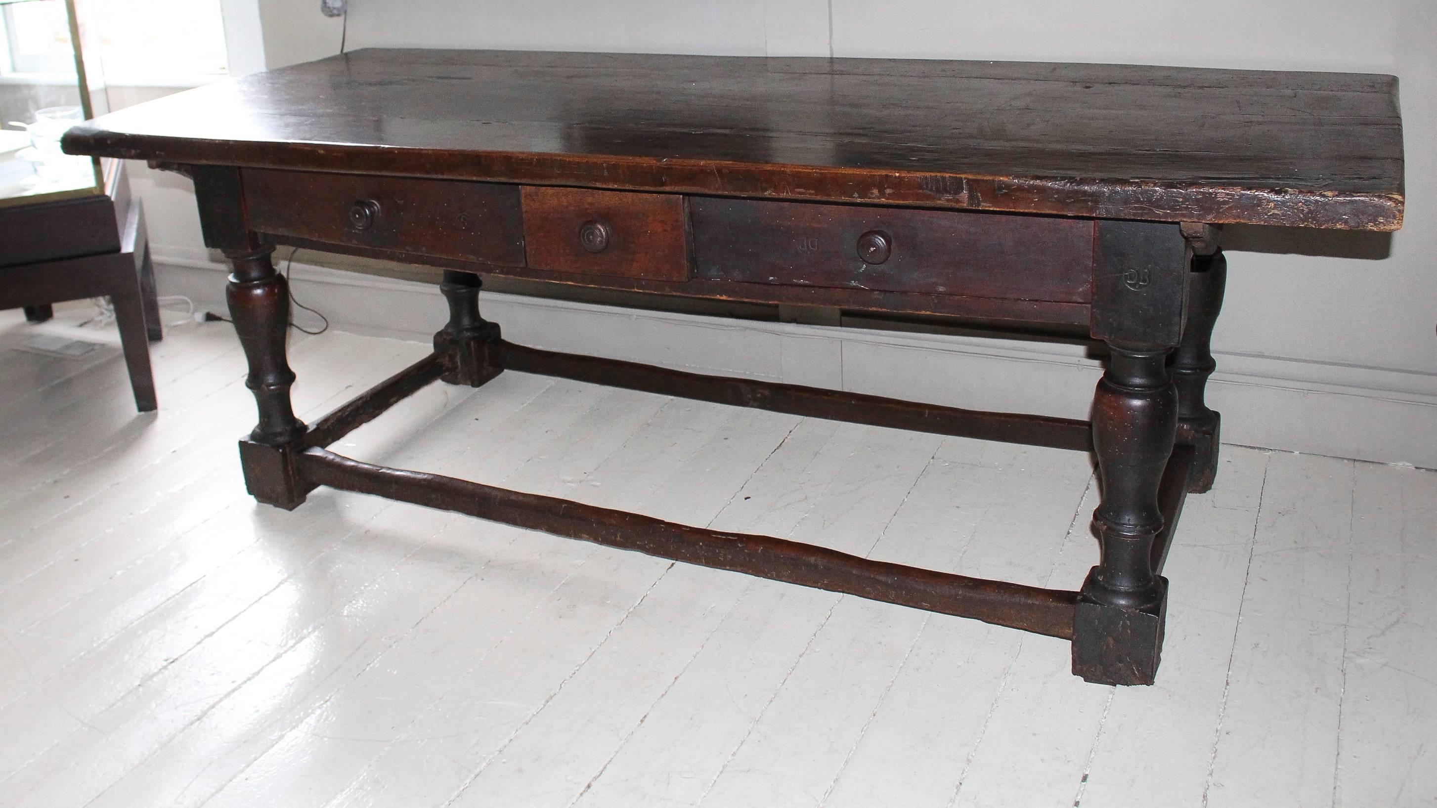 Wonderful massive trestle library table, 18th century Italian, with three drawers and large turned legs. Removable top is secured with side pegs. Branded Initials 