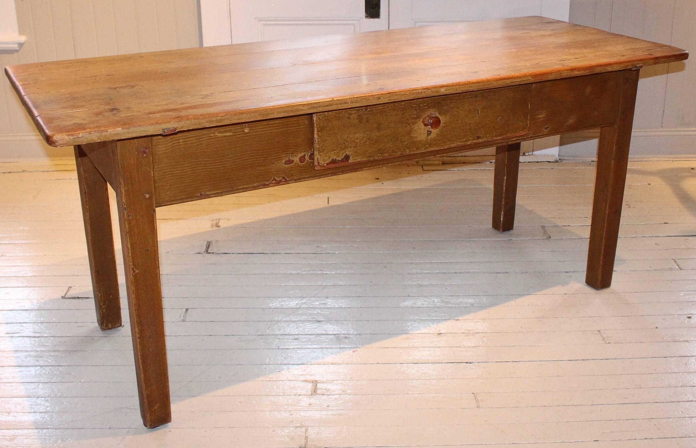 Antique long table, 19th century French with four-plank top. Table has two drawers, one in front and the other on the side.