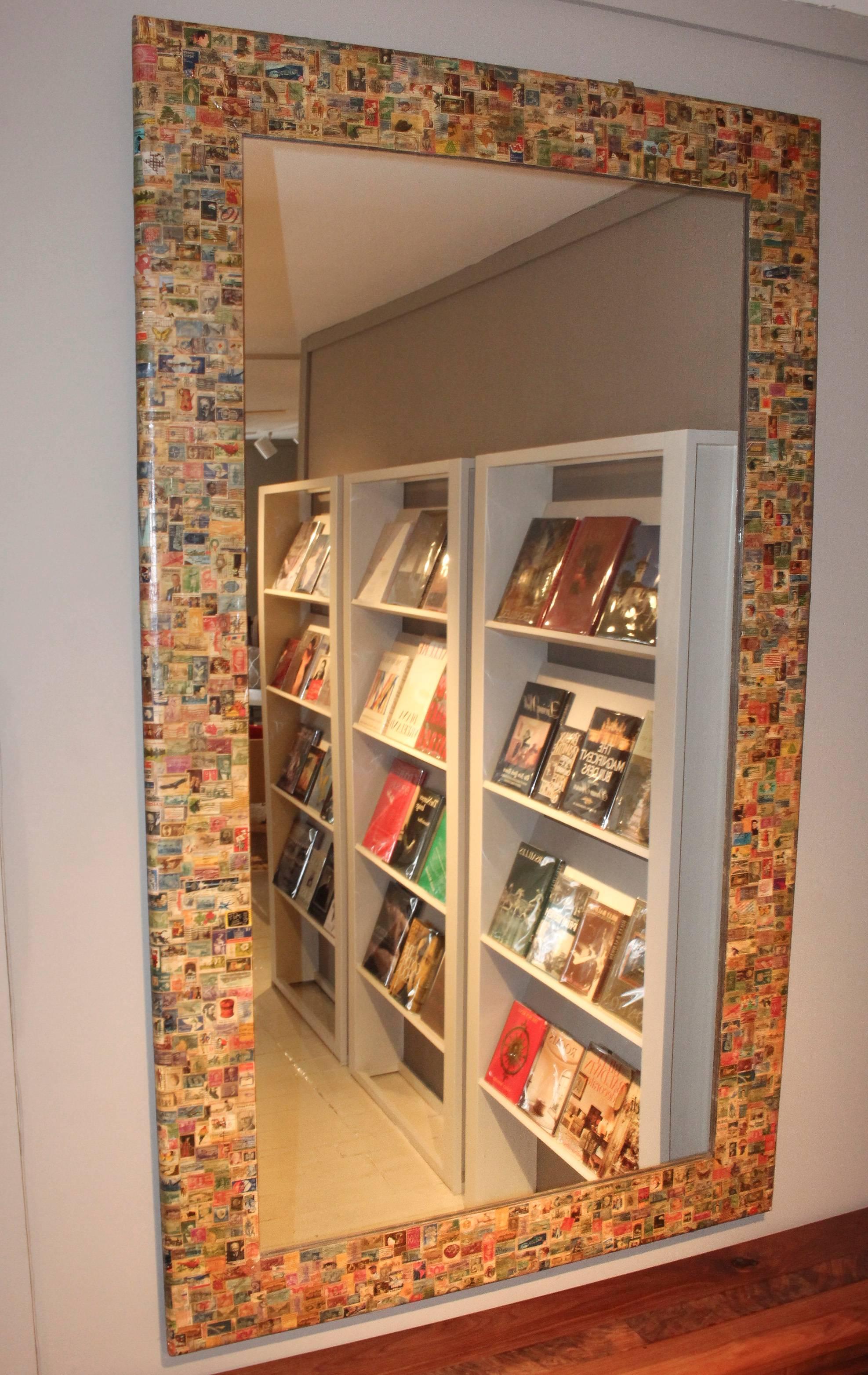 Monumental 20th century rectangular mirror encrusted with vintage US postage stamps. Mirror is on wood mount for added dimension and stability.