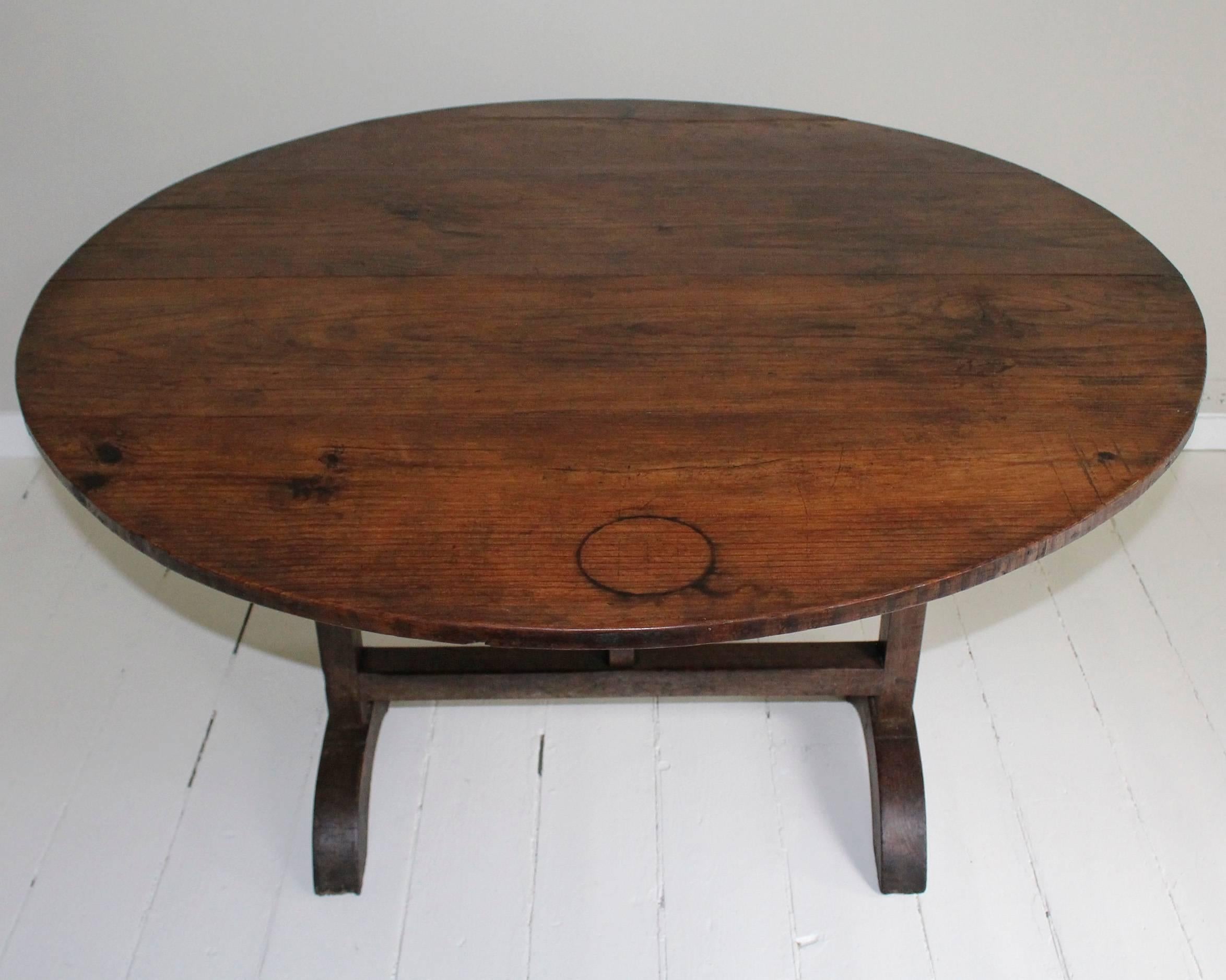 19th century French wine-tasting tilt-top table, round in shape, raised on trestle base with wishbone support. Stands 50.25" tall in upright folded position. Makes a perfect small breakfast table, library table or center hall table.