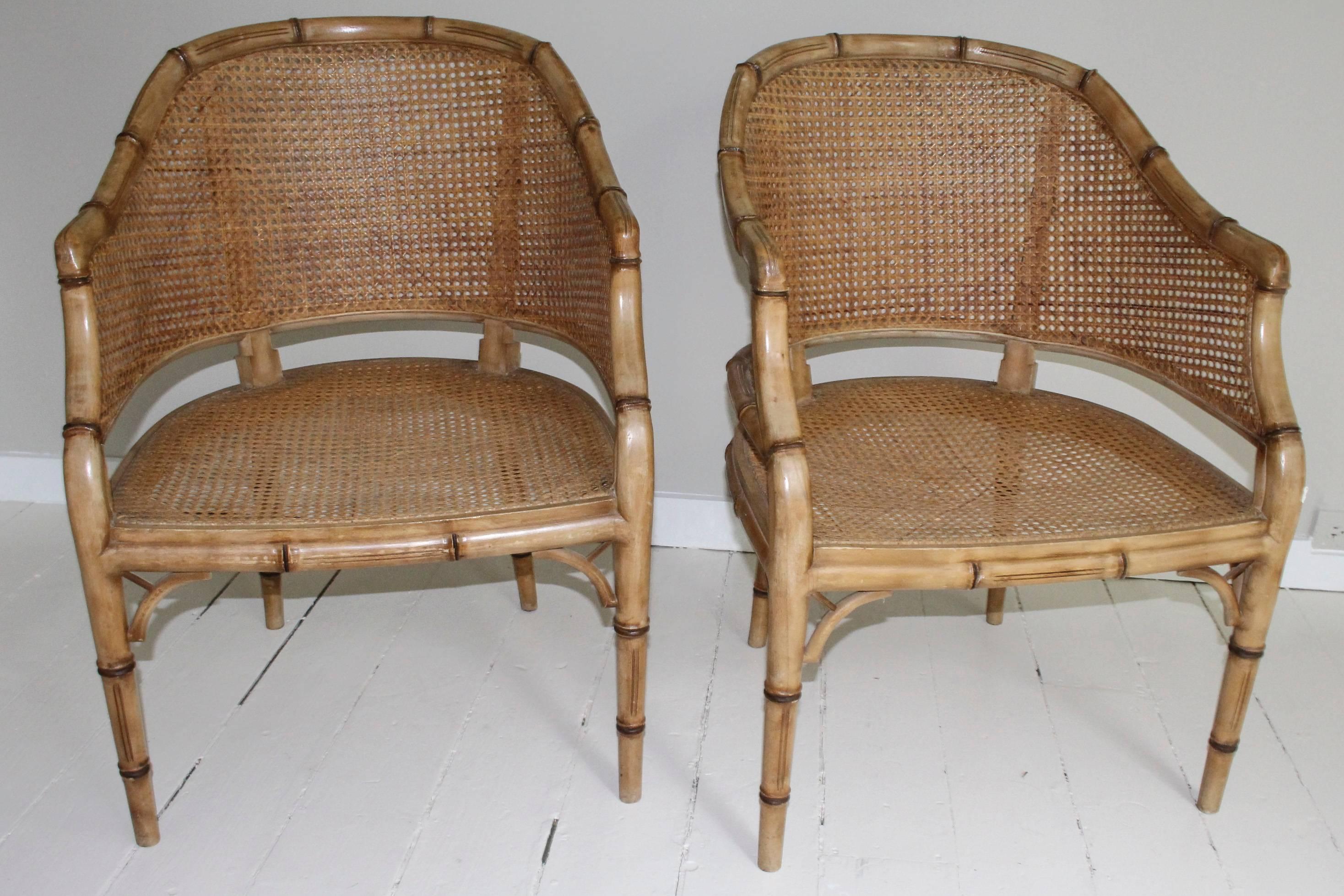 Pair of vintage French faux bamboo wood armchairs with Classic chinoiserie details, circa 1940s, with tub shaped backs, cane seats and backrest. Cushions included will need recovering.