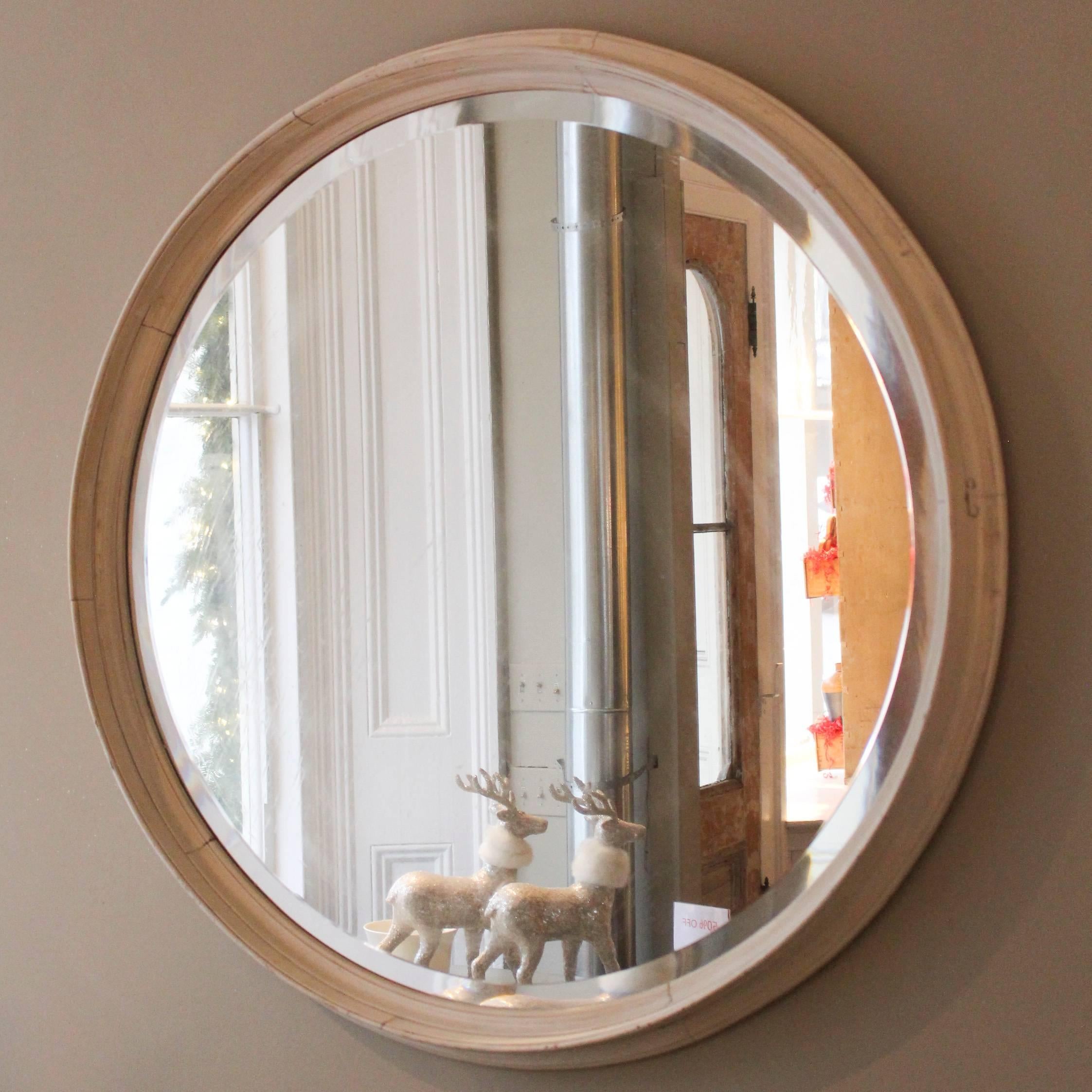 Outsized distressed bevelled glass round mirror, late 20th century with wood frame in oyster paint.