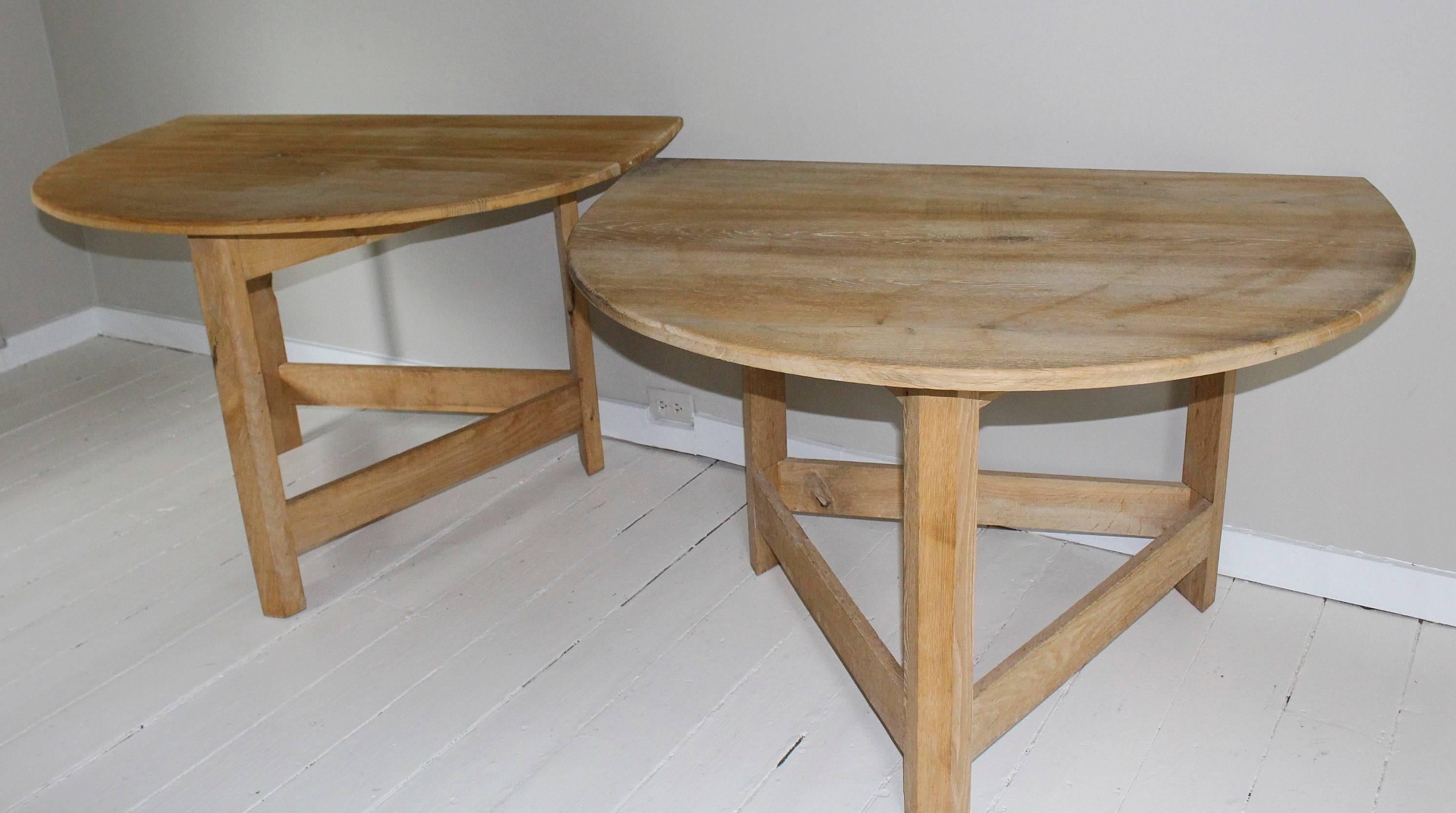 Pair of similar modern demilune tables in bleached maple with removable top hand-crafted of boards supported by three angular legs with stretchers. One table measures 45.5