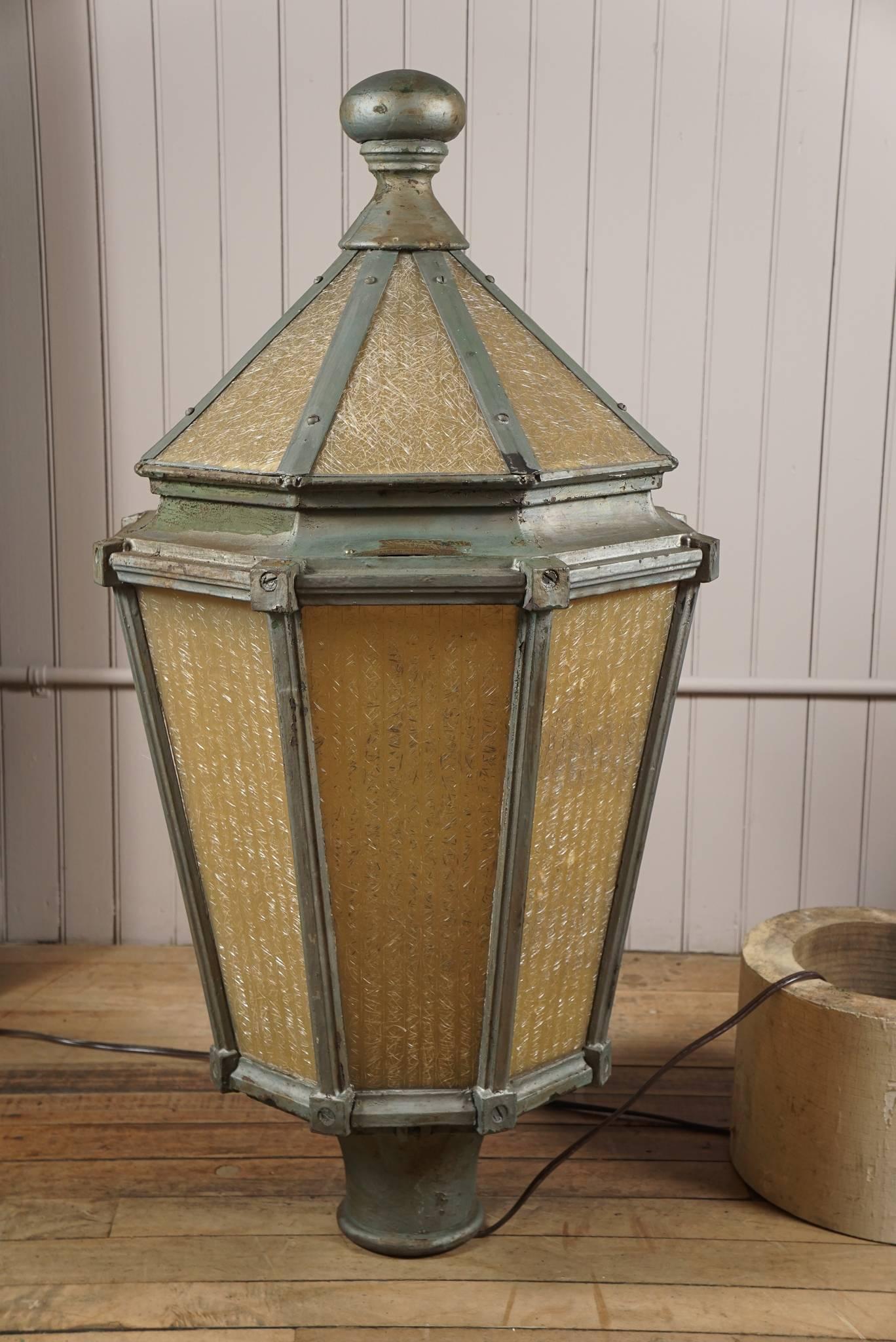 Pair of hexagonal post lamps - cast iron framework in old silver paint patina - fitted with patterned fiberglass panels emitting a golden glow - brass tag 