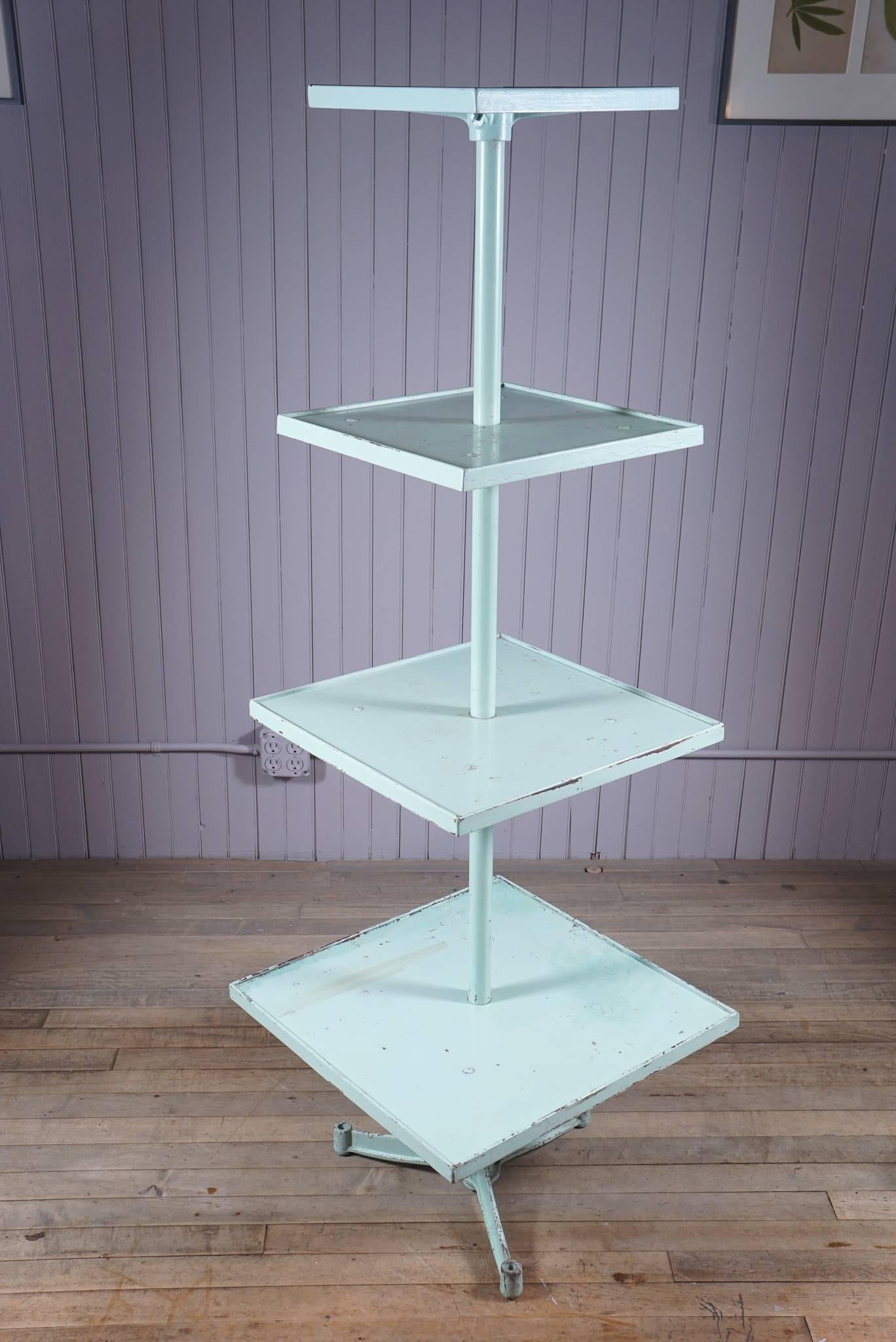 four square shelves with molded edging - graduated sizes - possibly adjustable - on pole with cast iron base
