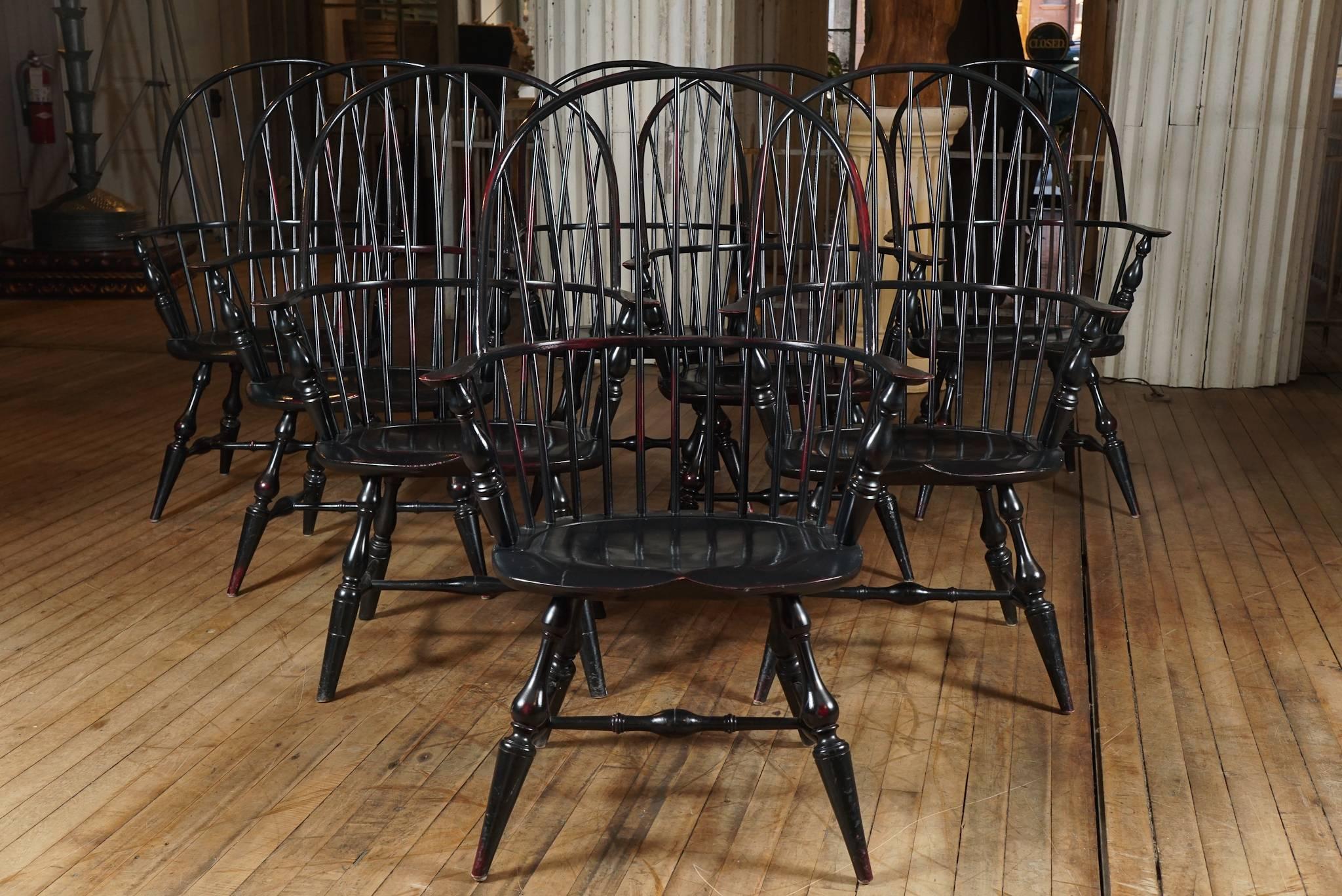 Set of eight sack back windsor armchairs, by the Riverbend Chair Co. Ohio. Black crackle surface over red, approximately 15 years old. Originally sold for @ $950. Decommissioned from a library - three sets of eight available.