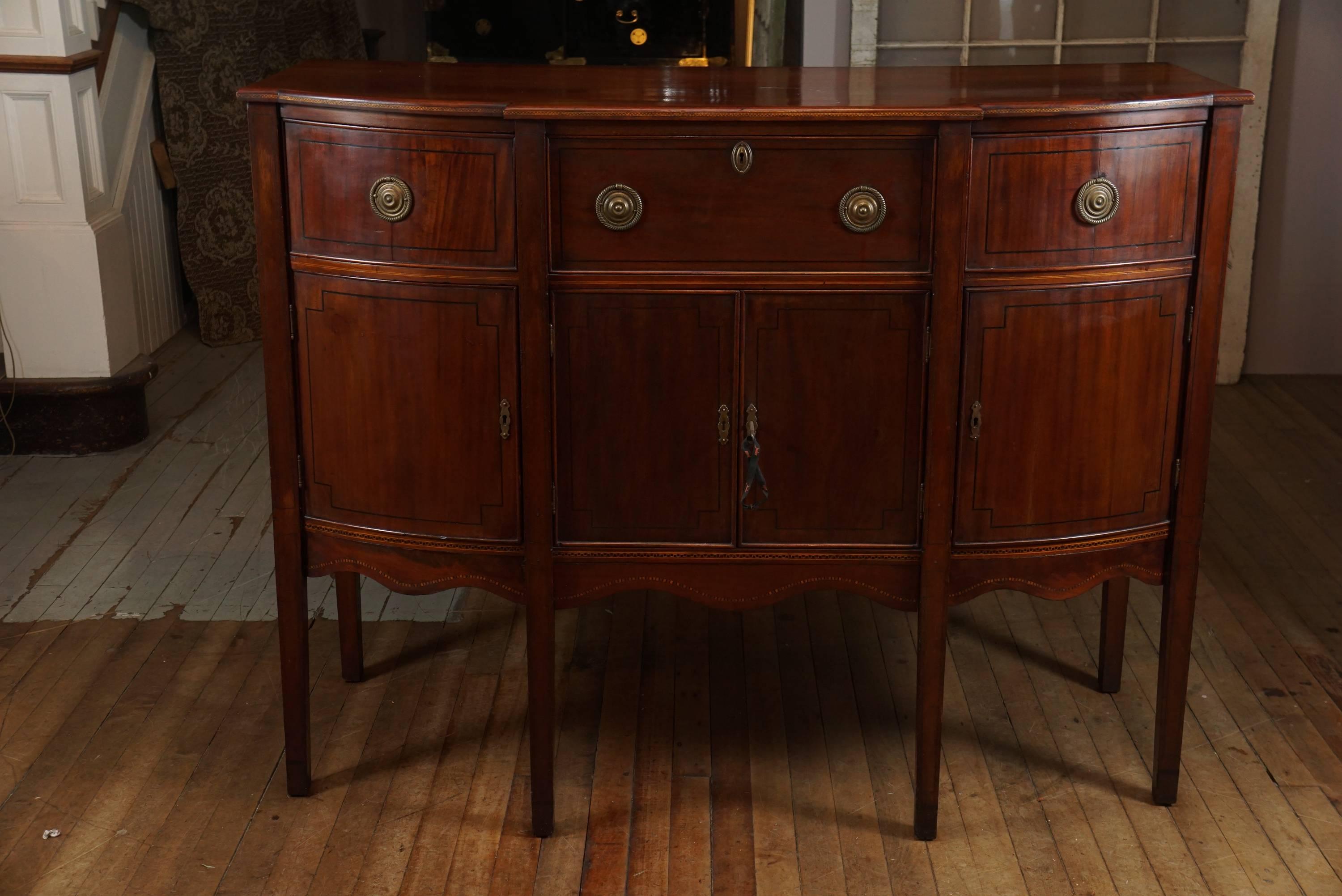 Sweet, stately, compact New England mahogany sideboard, black line inlay on tapered legs, support curved doors and drawers also outlined in black inlay, checkerboard string inlay grace skirted apron and solid mahogany top edge, original hardware,
