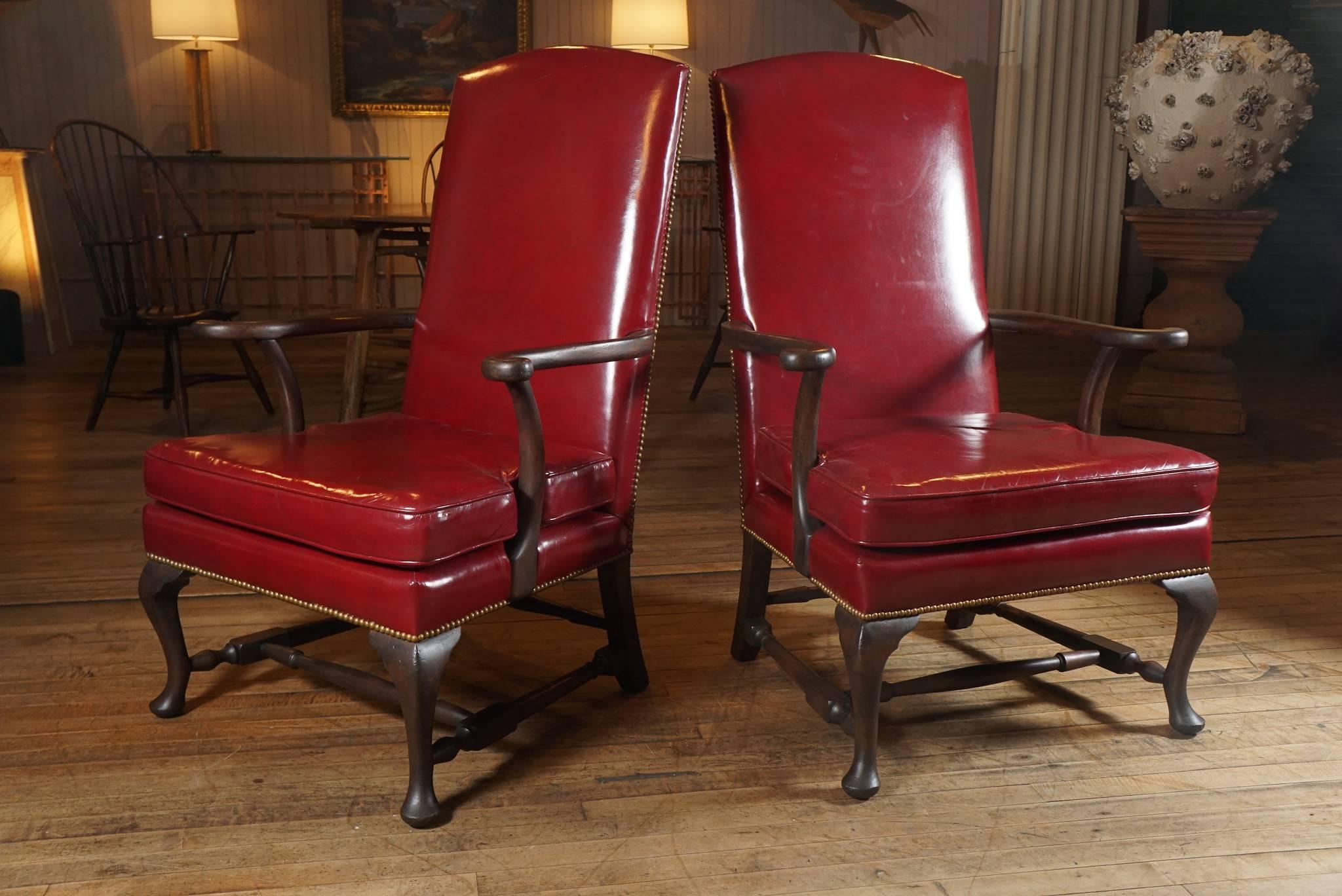 Handsome pair of Kittinger red leather lolling chairs - trimmed in brass tacks - dark brown wood stained arms and legs.