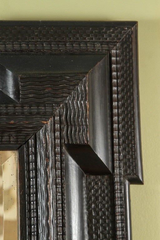 A Flemish ebonized frame, 17th century, with alternating rippled banding and cushion molding. Mirror plate is new.