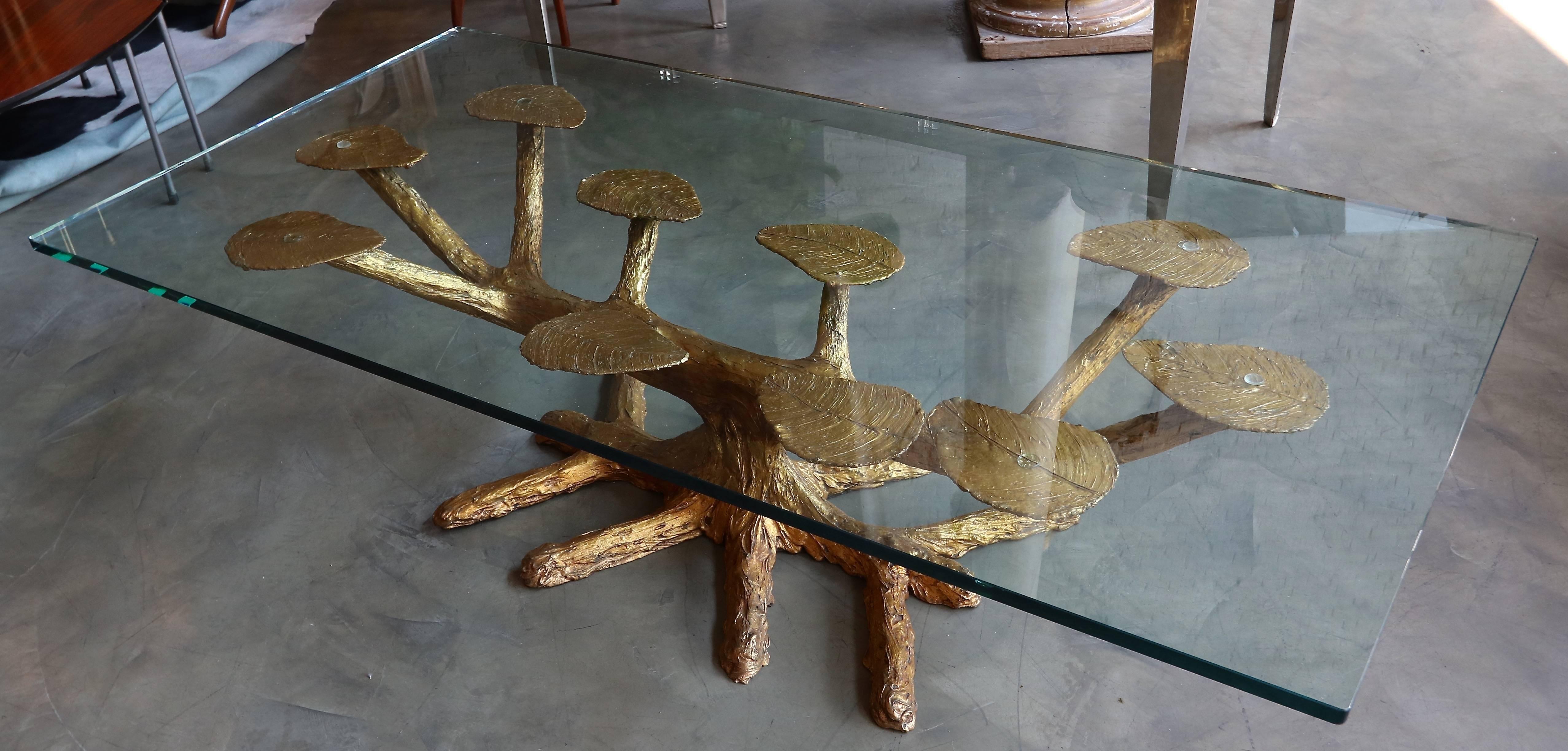 Metal faux bois 1960s coffee table with gold finish in the shape of a tree. Glass top sits on leaves.