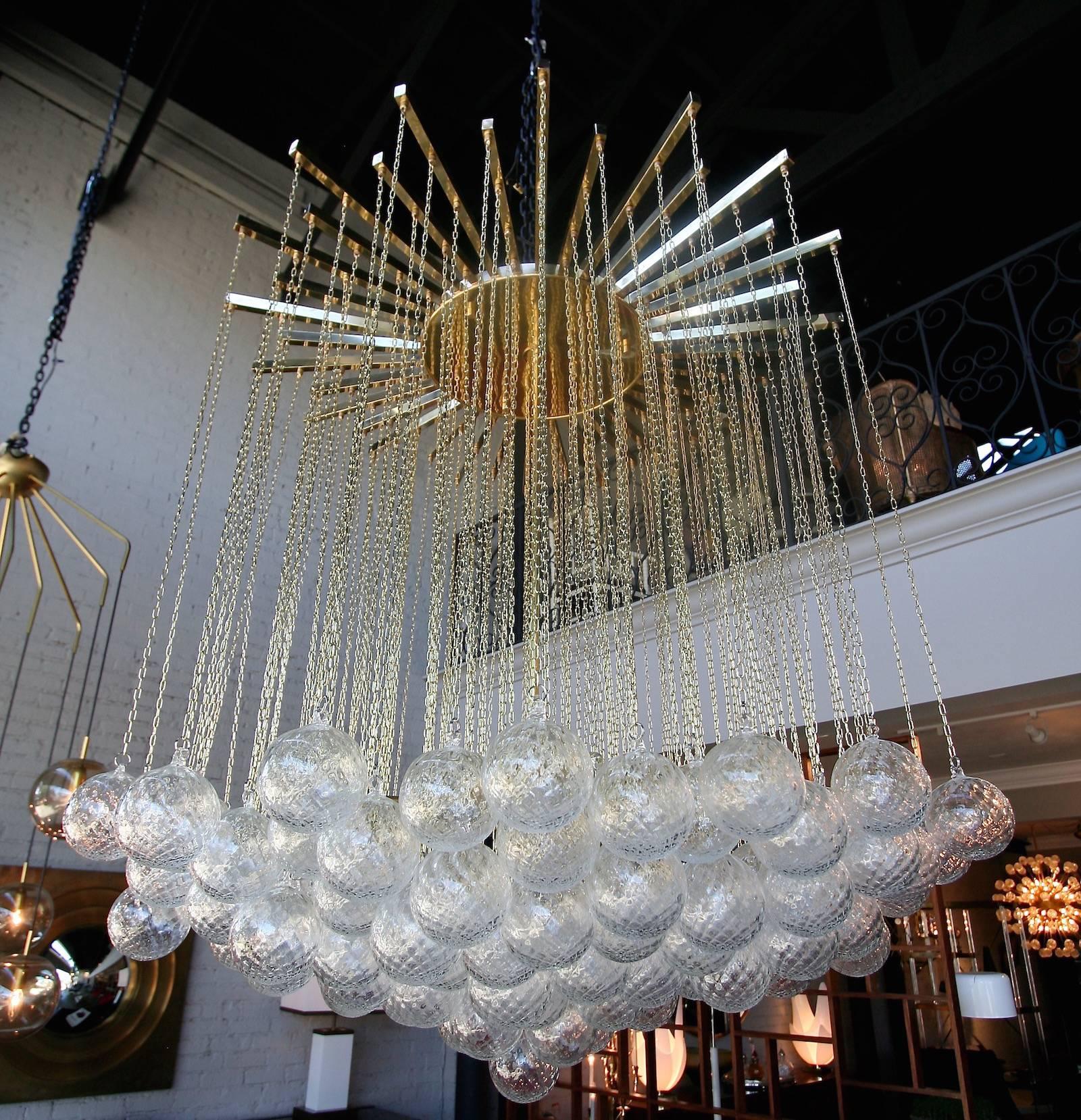 1970s Italian midcentury chandelier with 137 clear glass balls hanging from fine brass chains from a starburst frame.
