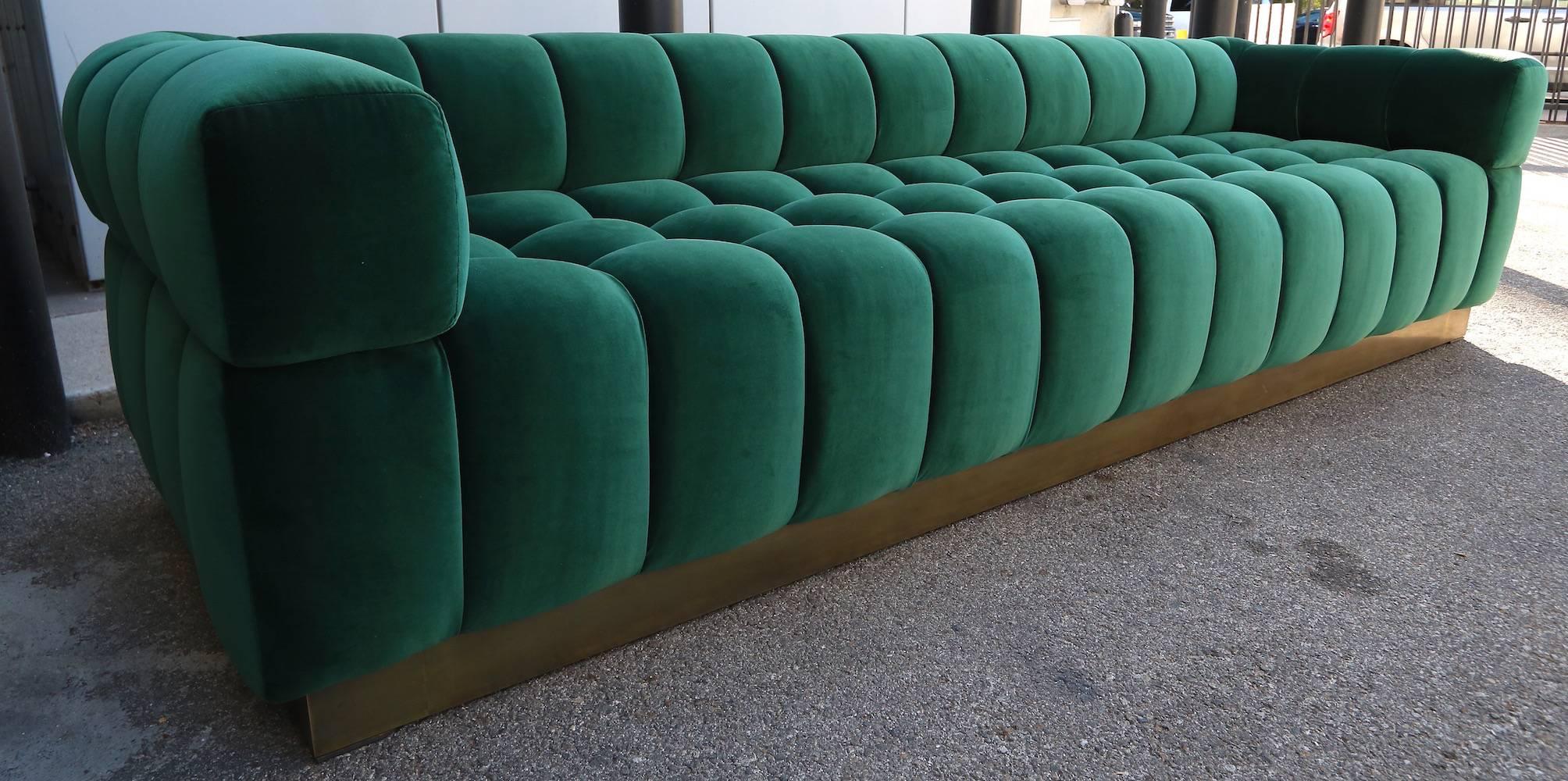 Custom tufted sofa with brass base, in dark green Belgium velvet by Adesso Imports. Can be made in different colors and fabrics or a different metal for the base.