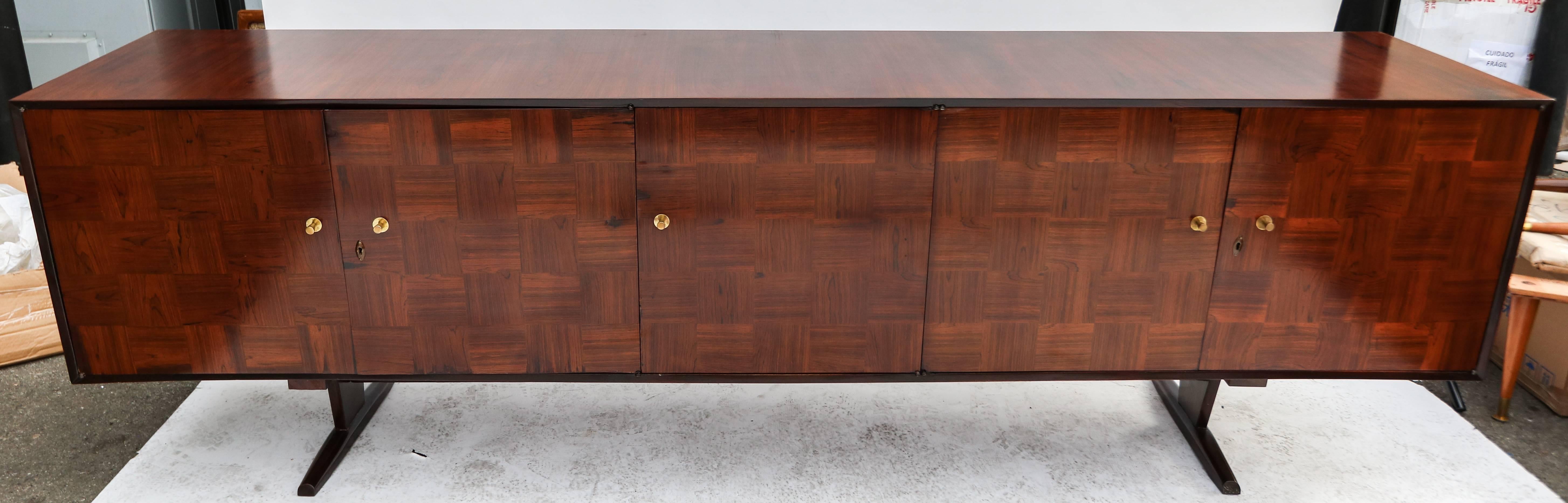 Brown 1960s Brazilian jacaranda wood sideboard by Scapinelli in a parquet checkerboard pattern with brass hardware. The two end cabinets have two shelves. The single middle cabinet has drawers.